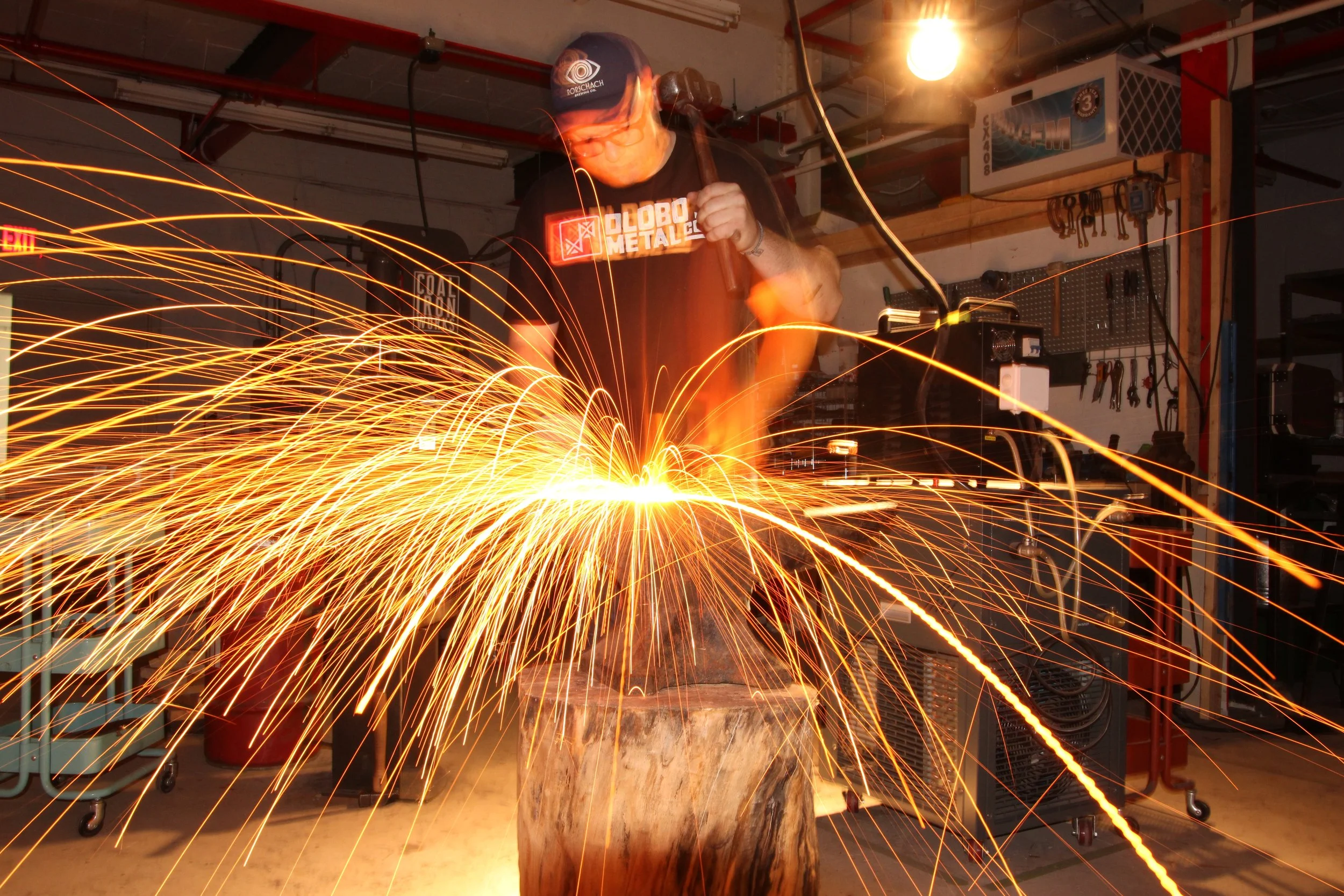 Blacksmith working with heated metal at his anvvvil.