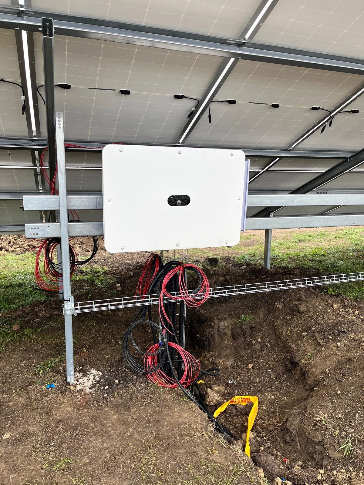 Föld alatti elektromos vagy napelem kábelezés kialakítása egy napelempark alatt, a vezetékek bekötése egy Inverterbe