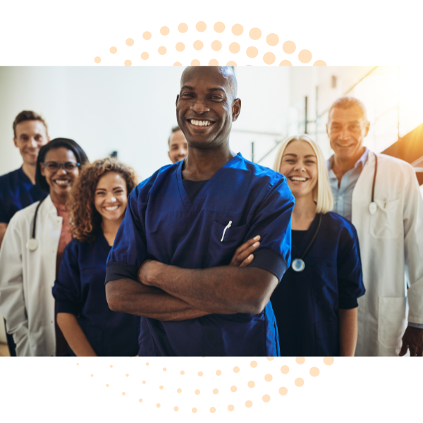 A diverse group of healthcare professionals, including doctors and nurses, standing together in a hospital with sunlight coming through the windows, smiling confidently.