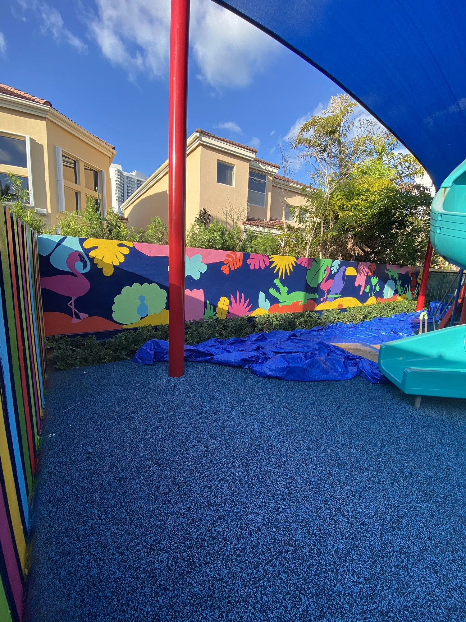 Day 5 progress Shot: Community Playground Mural in Island Way Aventura, FL. Day 1 Progress Shot (40' L x 5' H not including the fence area) 5 days to complete. Spray paint & House paint, Free Hand.