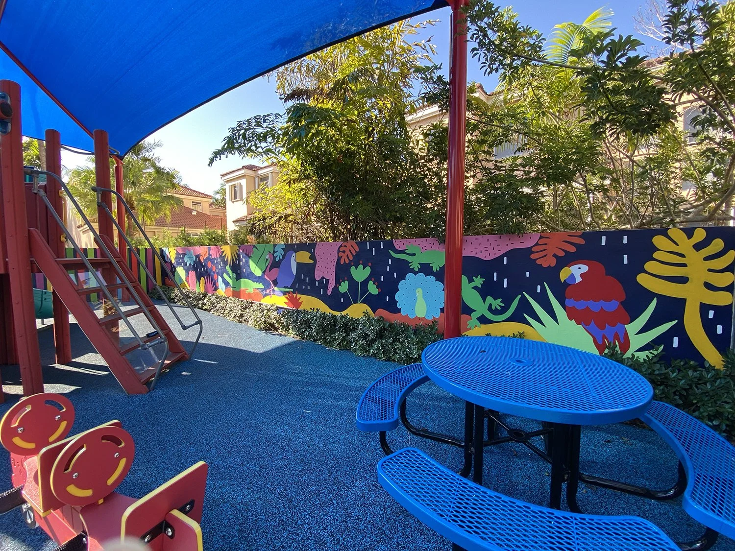 Completed: Community Playground Mural in Island Way Aventura, FL. Day 1 Progress Shot (40' L x 5' H not including the fence area) 5 days to complete. Spray paint & House paint, Free Hand.