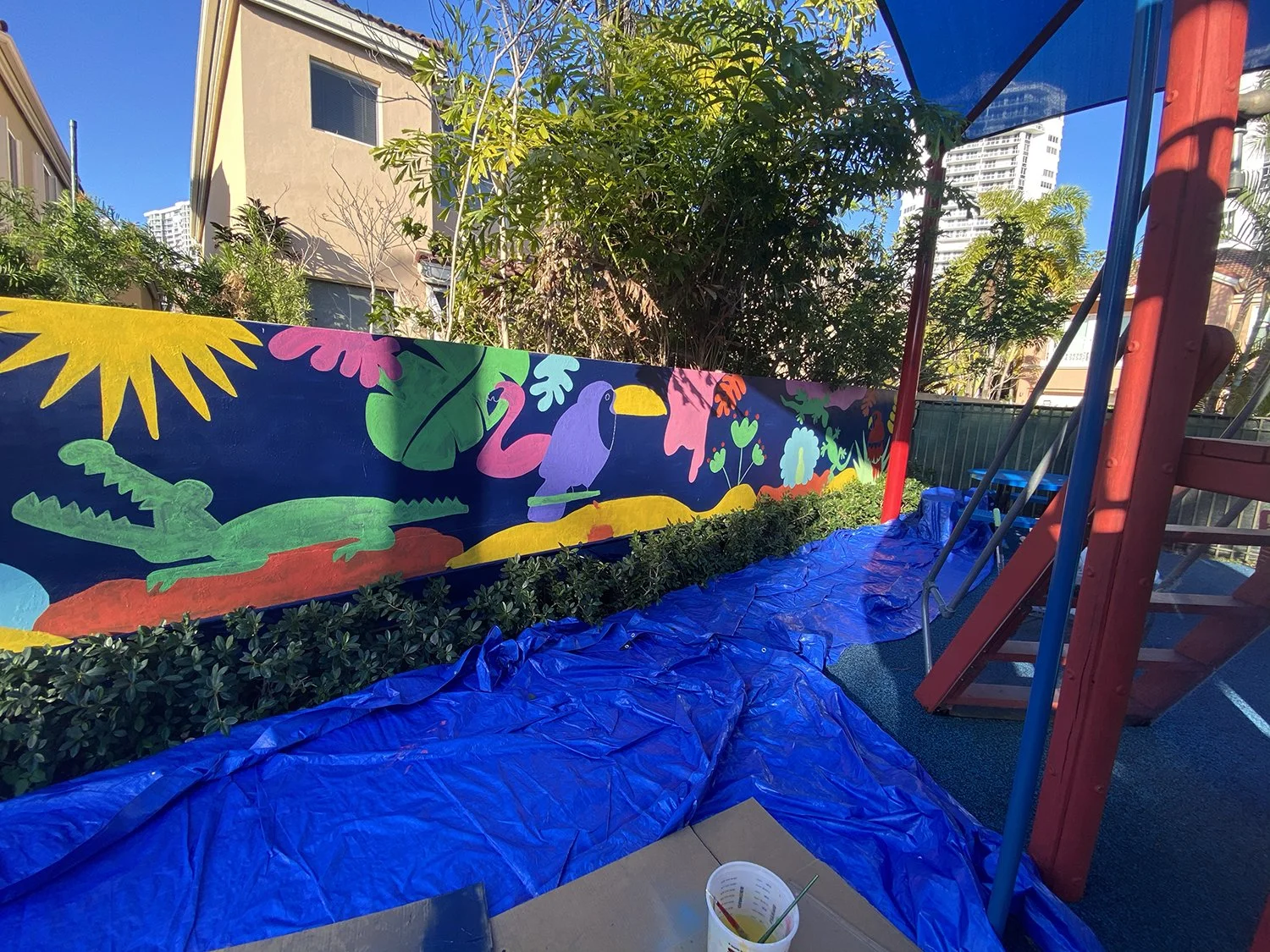 Day 4 progress Shot: Community Playground Mural in Island Way Aventura, FL. Day 1 Progress Shot (40' L x 5' H not including the fence area) 5 days to complete. Spray paint & House paint, Free Hand.