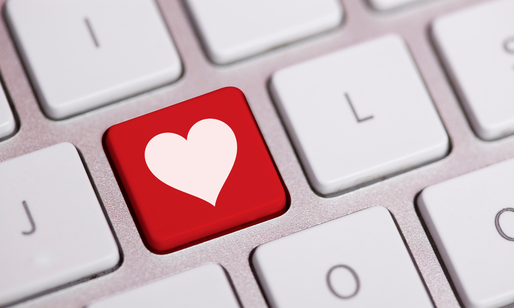 Close-up of a computer keyboard with a red key featuring a white heart symbol.