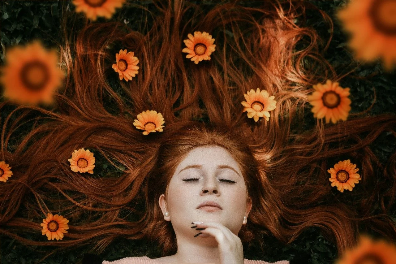 Redhead lying with flowers in hair