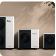 Three large white and black home appliances, likely air conditioners, on a beige wall background.