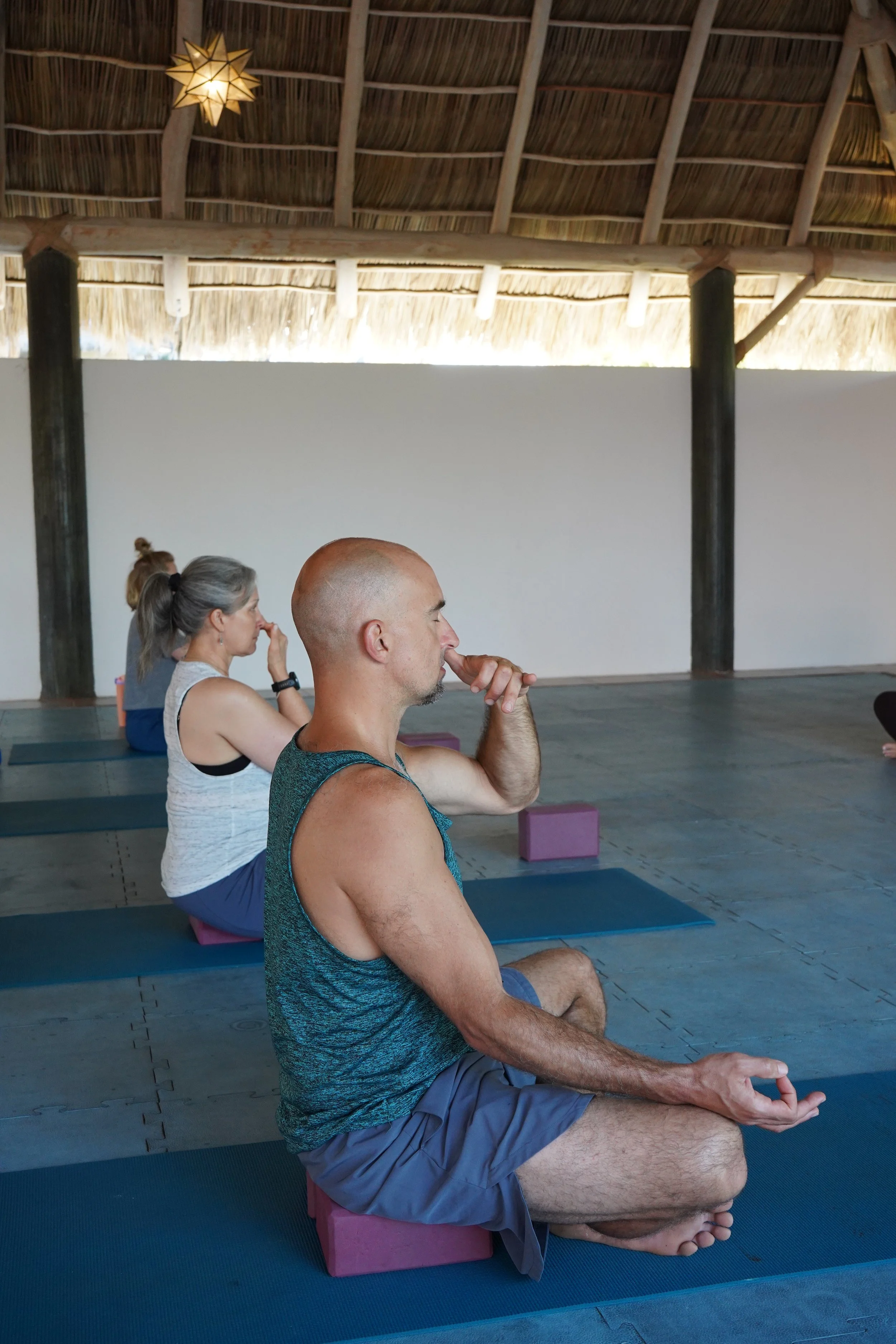 Guest practicing pranayama and meditation during a morning yoga session at a Sol Collective retreat in Sayulita, Mexico