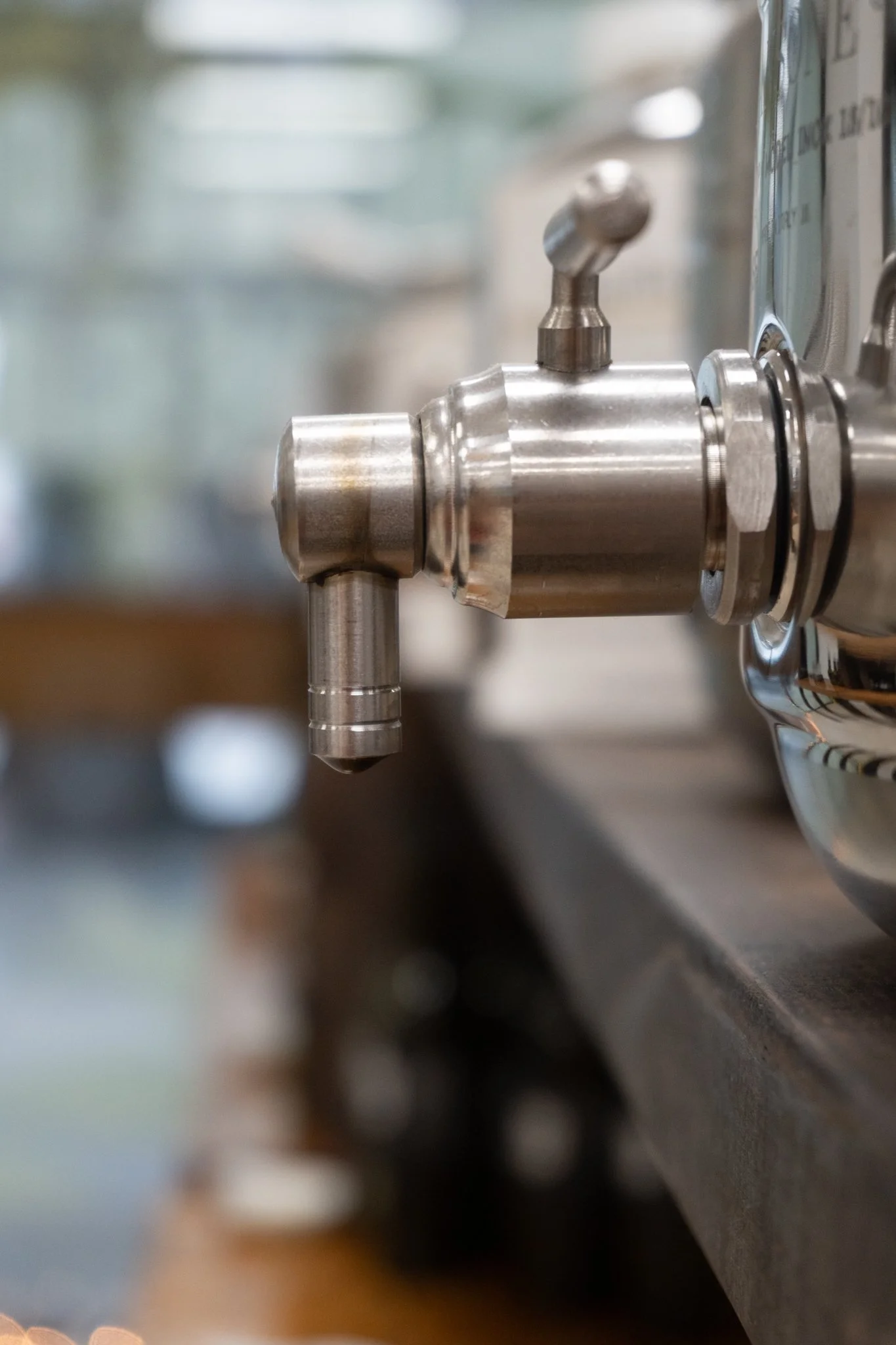 Close-up of a stainless steel espresso machine portafilter spout.