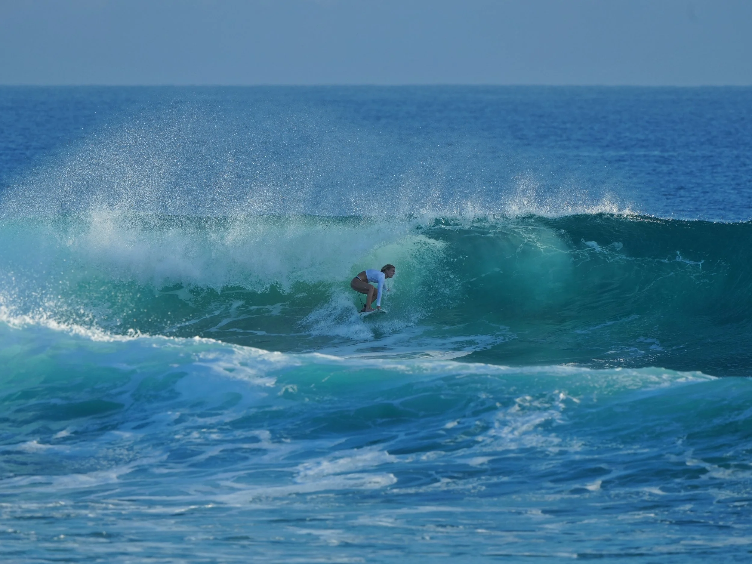 Georgina pulling into a barrelling wave on her surfboard