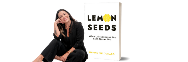 A woman sitting and smiling next to a book titled 'Lemon Seeds' by Nadine Maldonado, featuring a yellow lemon slice on the cover.