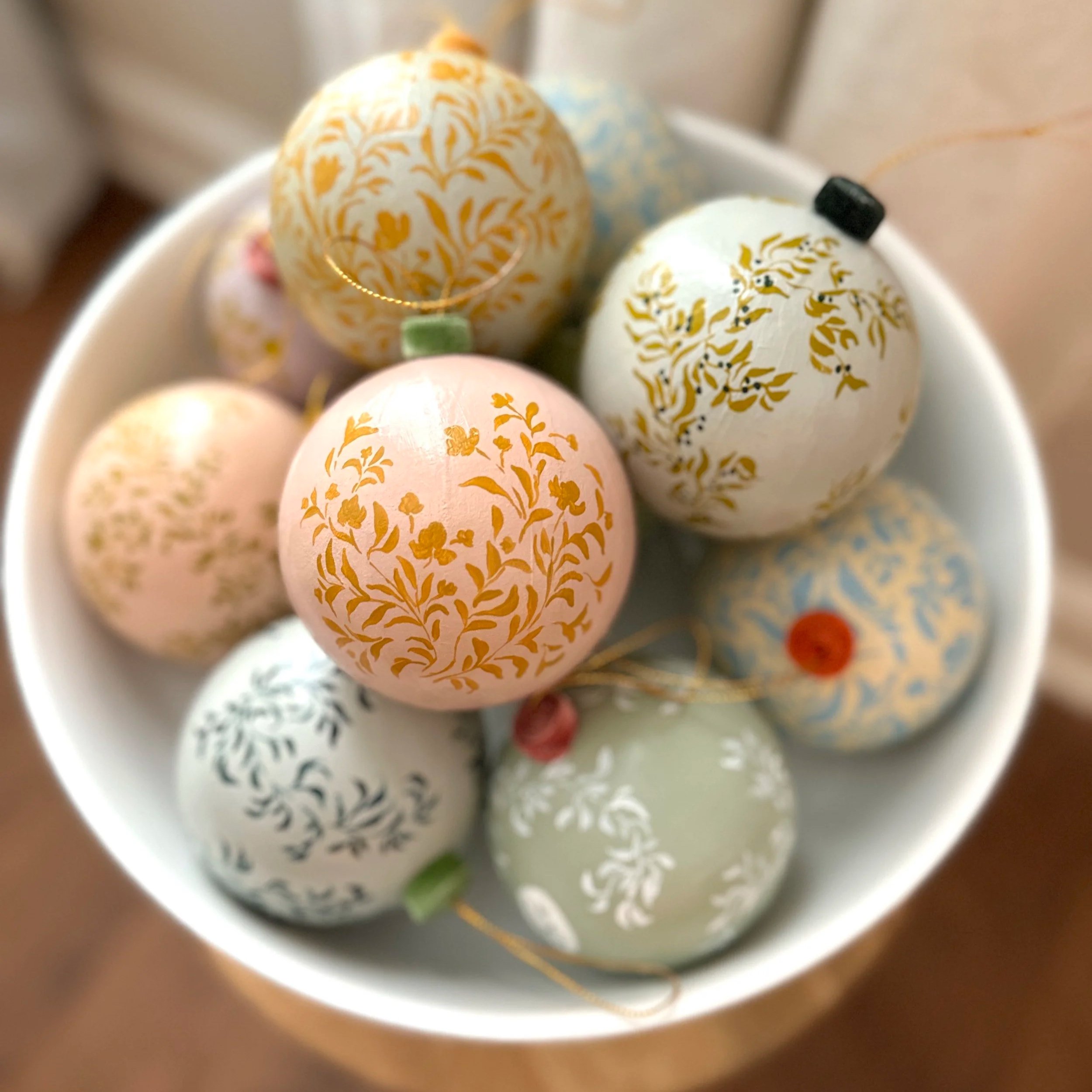 Bowl of hand painted paper mache Christmas ornaments by Blair Frazier Art