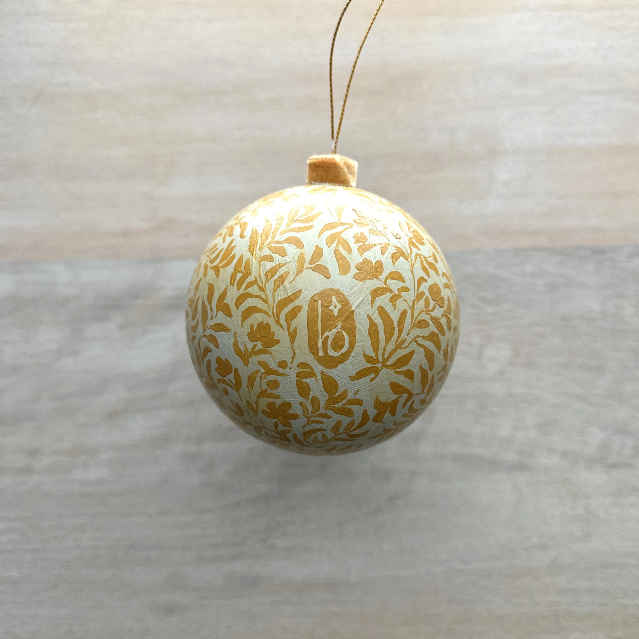 Paper mache Christmas ornament with hand painted botanicals and Blair Frazier Art logo