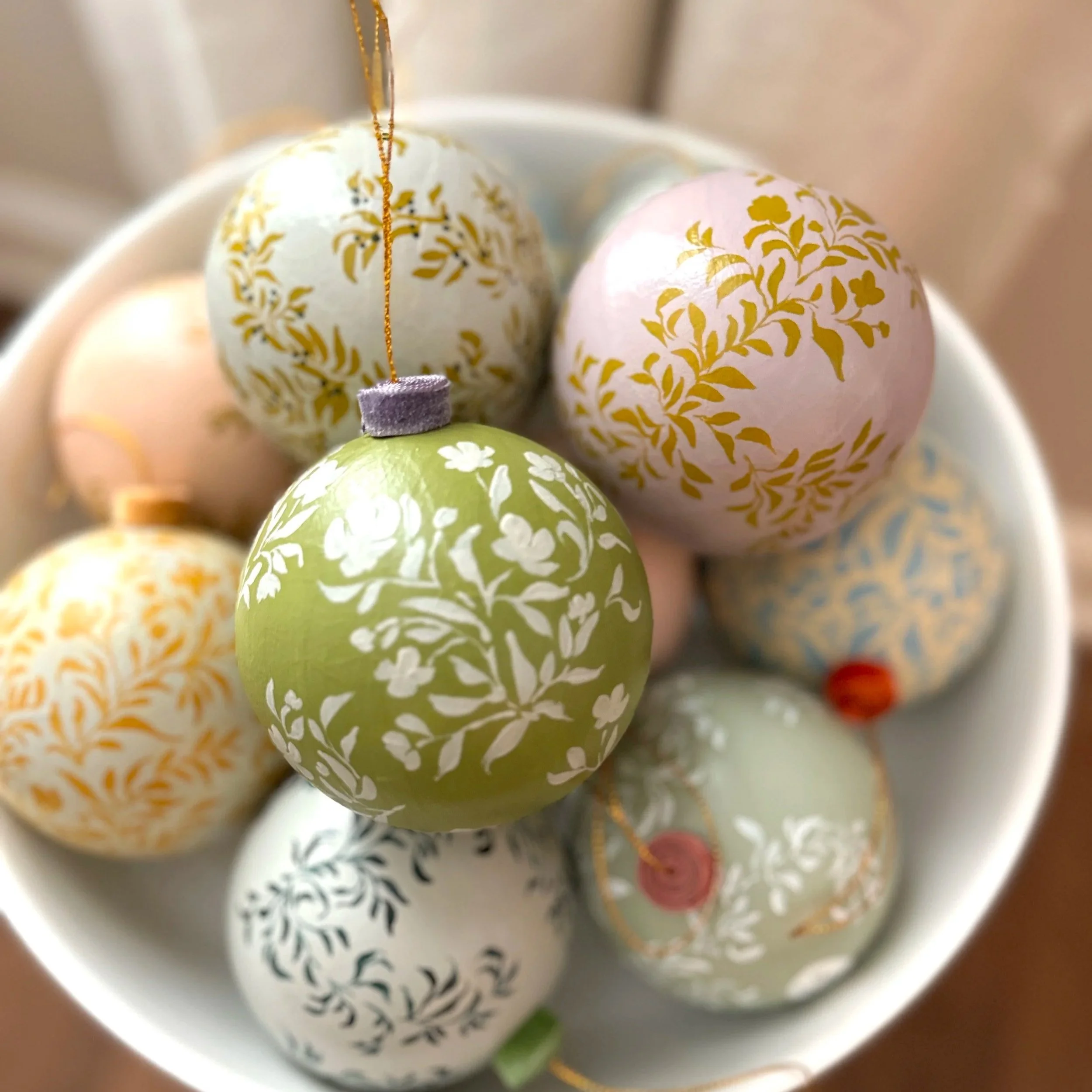 Bowl of hand painted paper mache Christmas ornaments by Blair Frazier Art