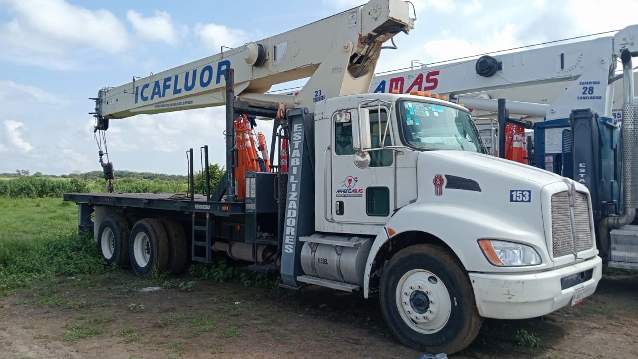 Camión con plataforma elevadora en un campo verde.