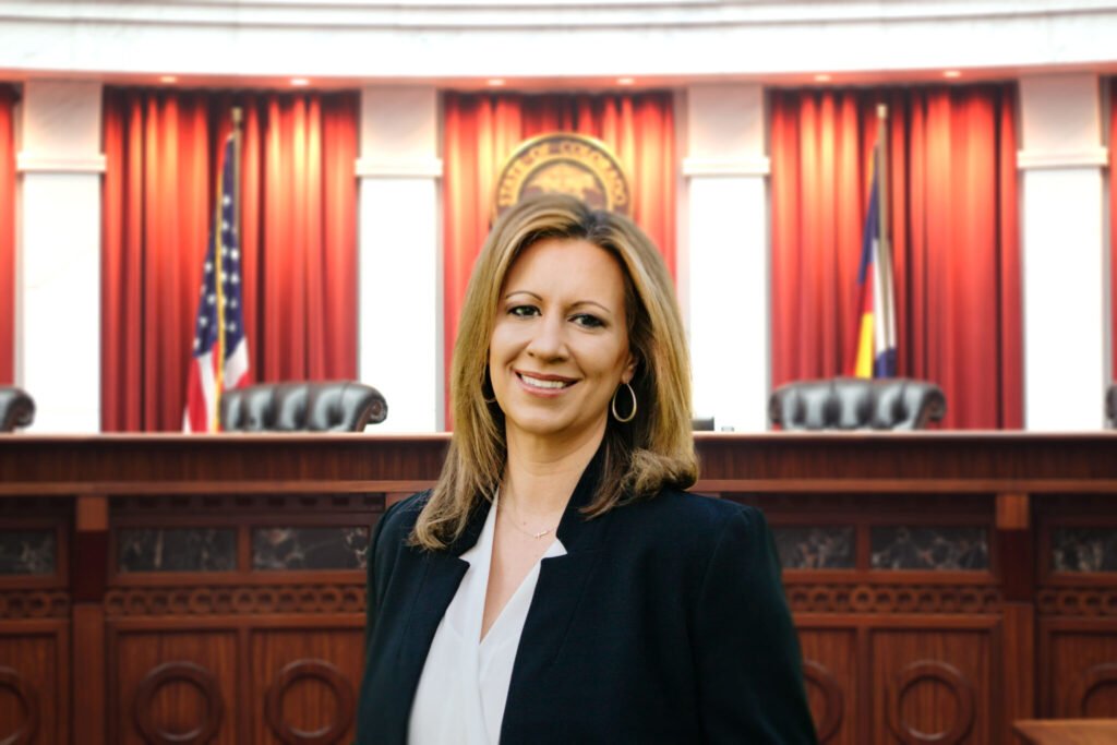 Suzanne Karrer at the Colorado Supreme Court chambers, with the bench behind her