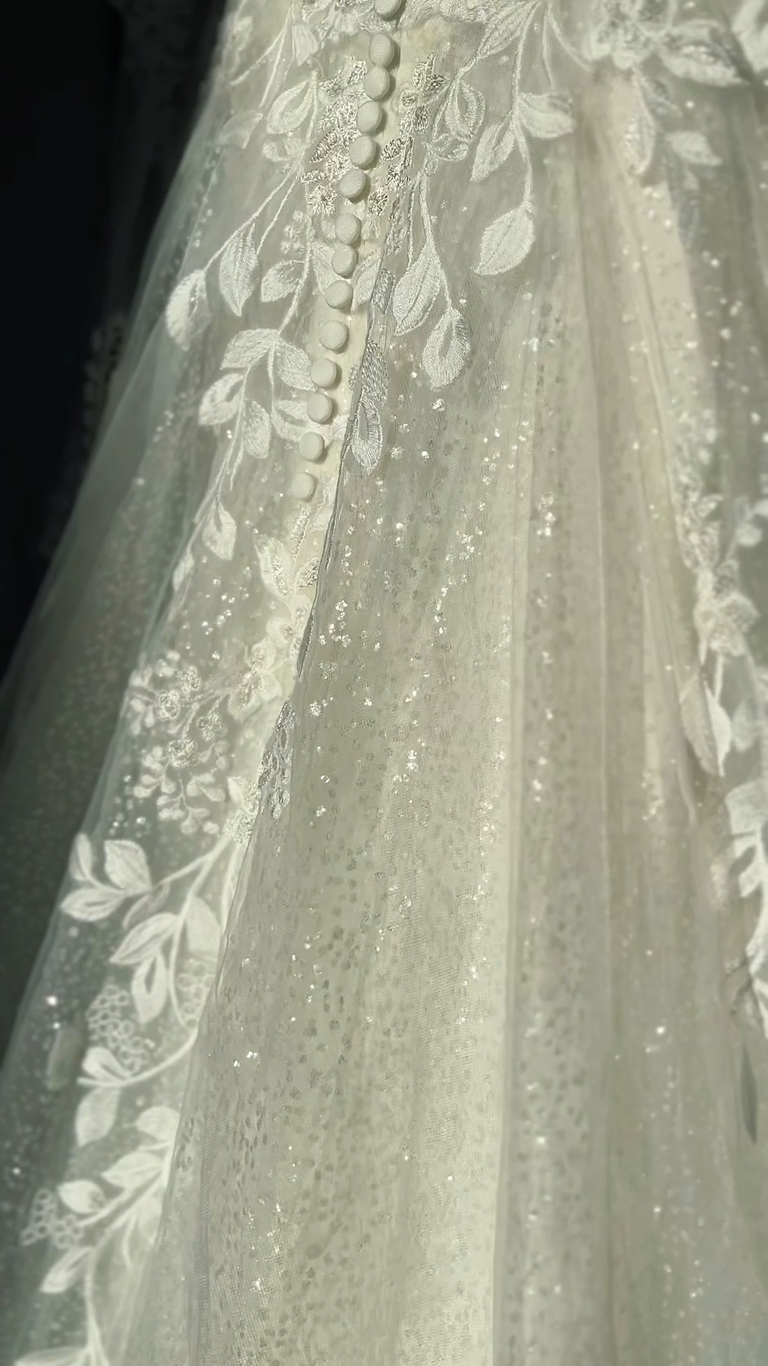 Close-up view of a wedding dress with intricate lace and beadwork.