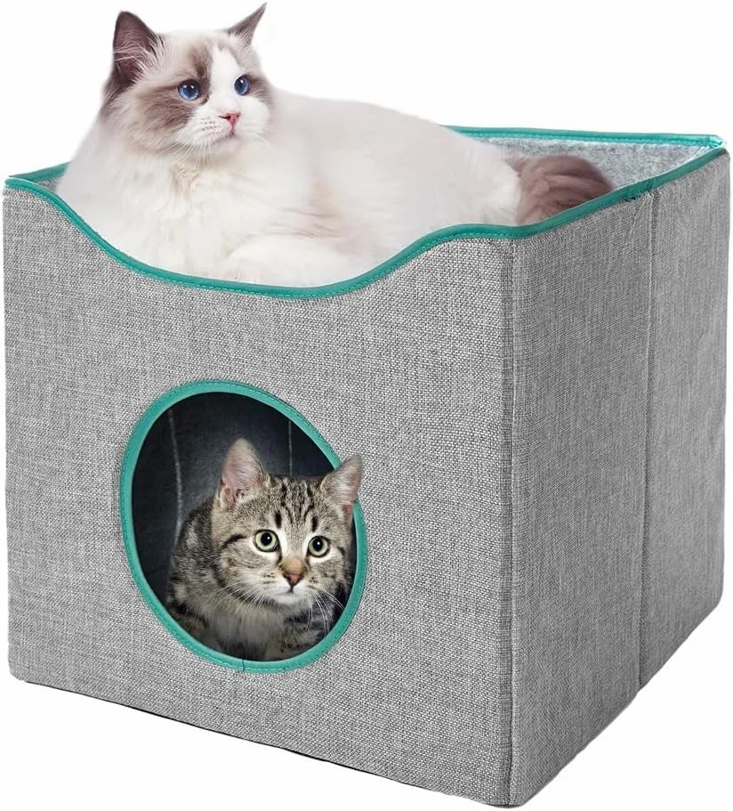 A white and gray cat with blue eyes lying on top of a fabric cat furniture with a pet house enclosed.