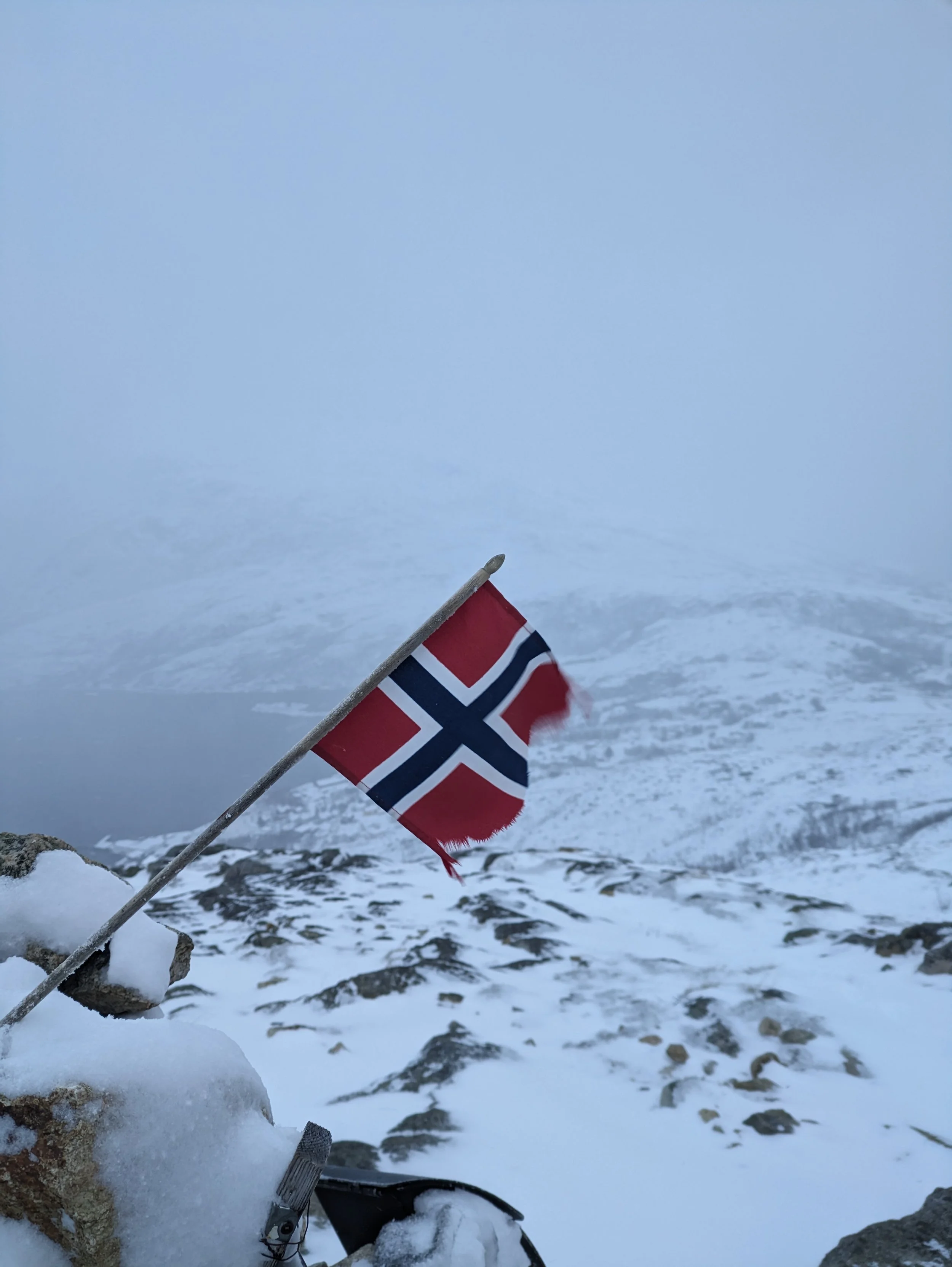 A proud Norwegian flag waving in the wind. A great symbol of the beautiful country and a perfect photo to capture the feeling of adventure