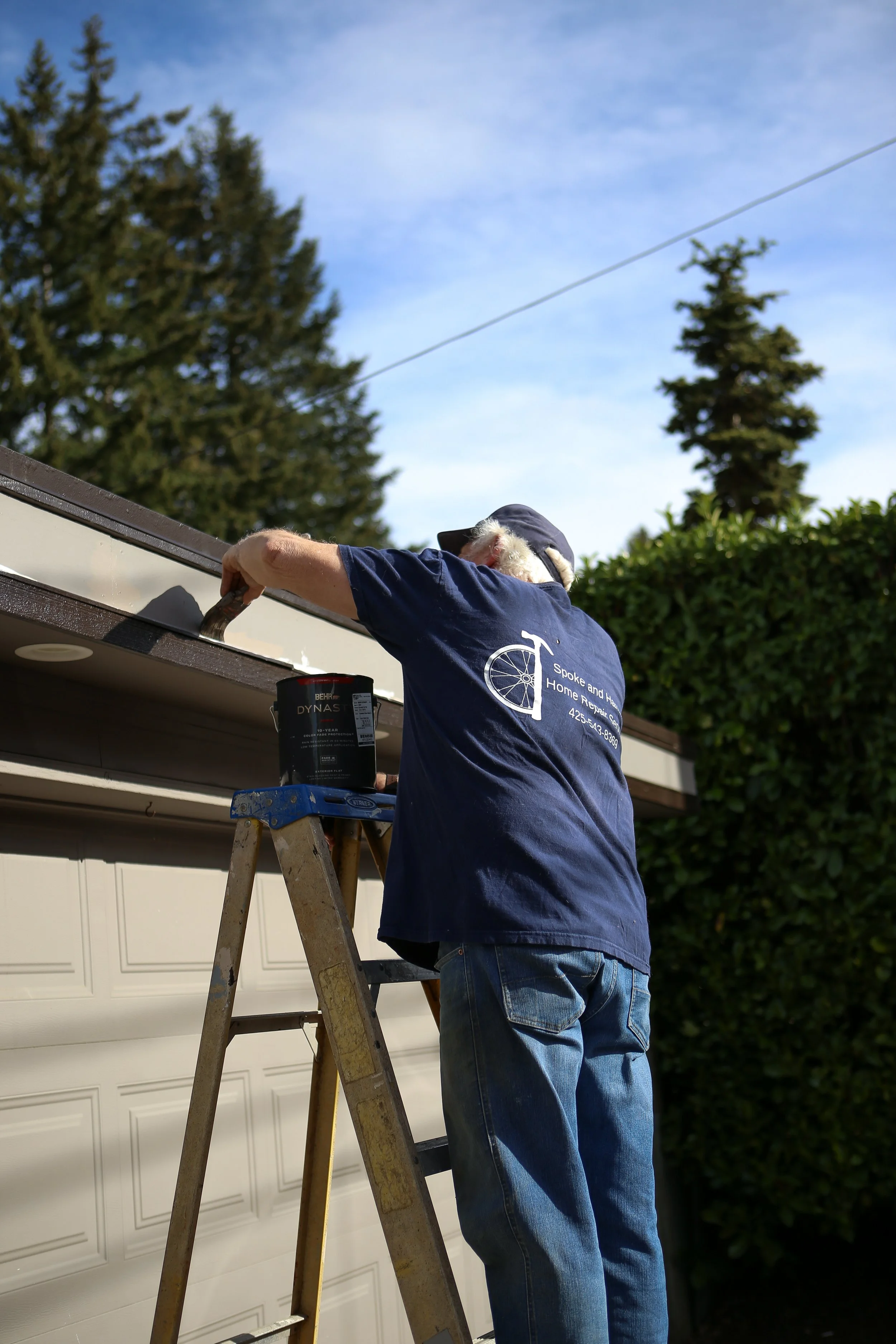 Painting trim, siding, and garage doors.