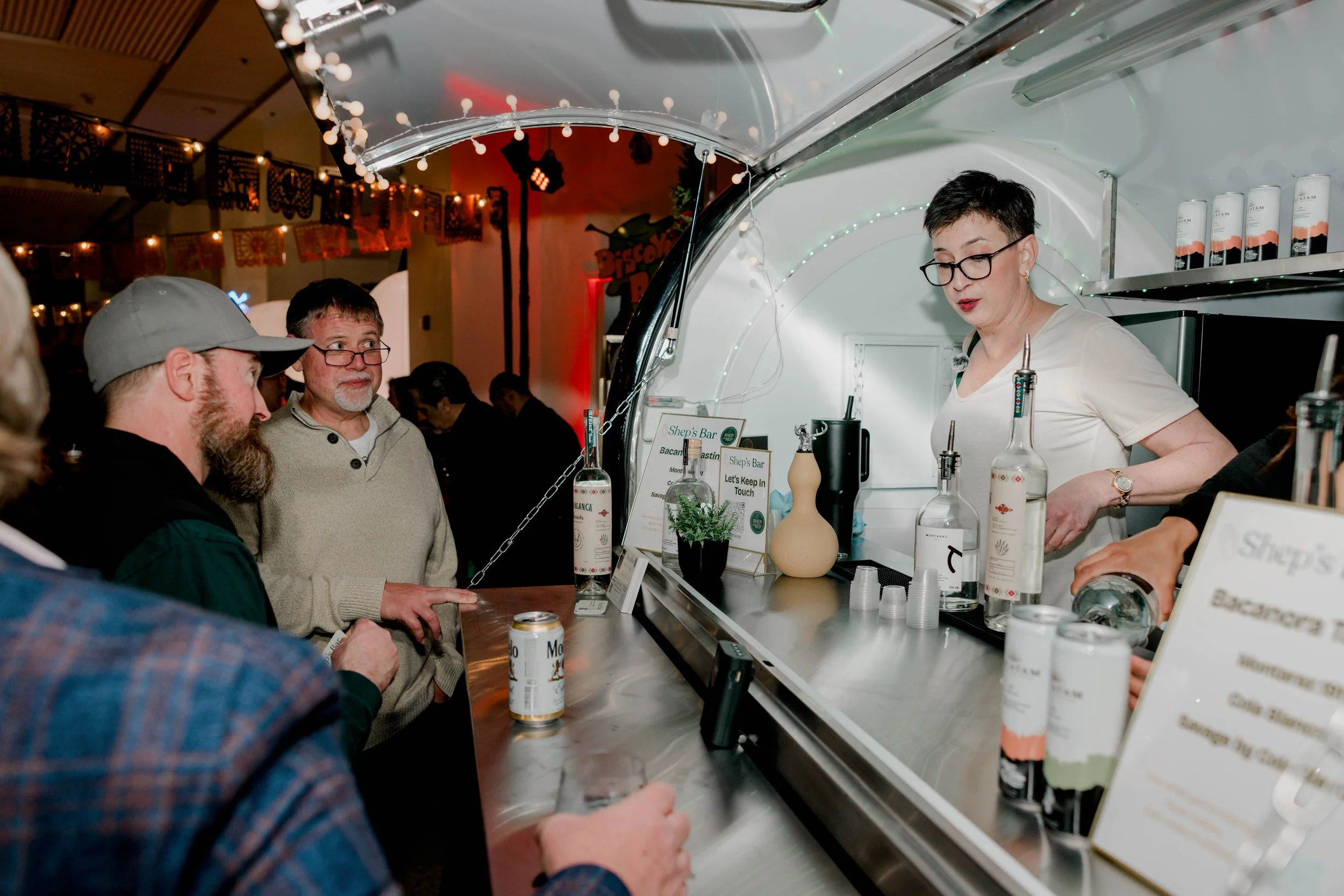 Shep hosting guests at an interactive spirits tasting inside the mobile bar trailer.