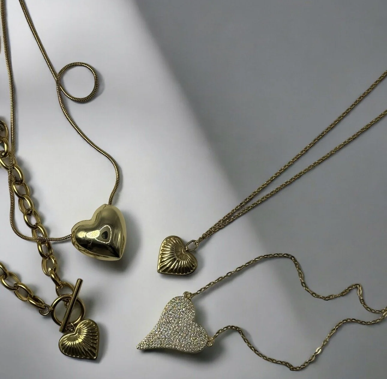 Gold necklace with a teardrop pendant on a white jewellery display bust. Available from Chain Rule Jewellery.