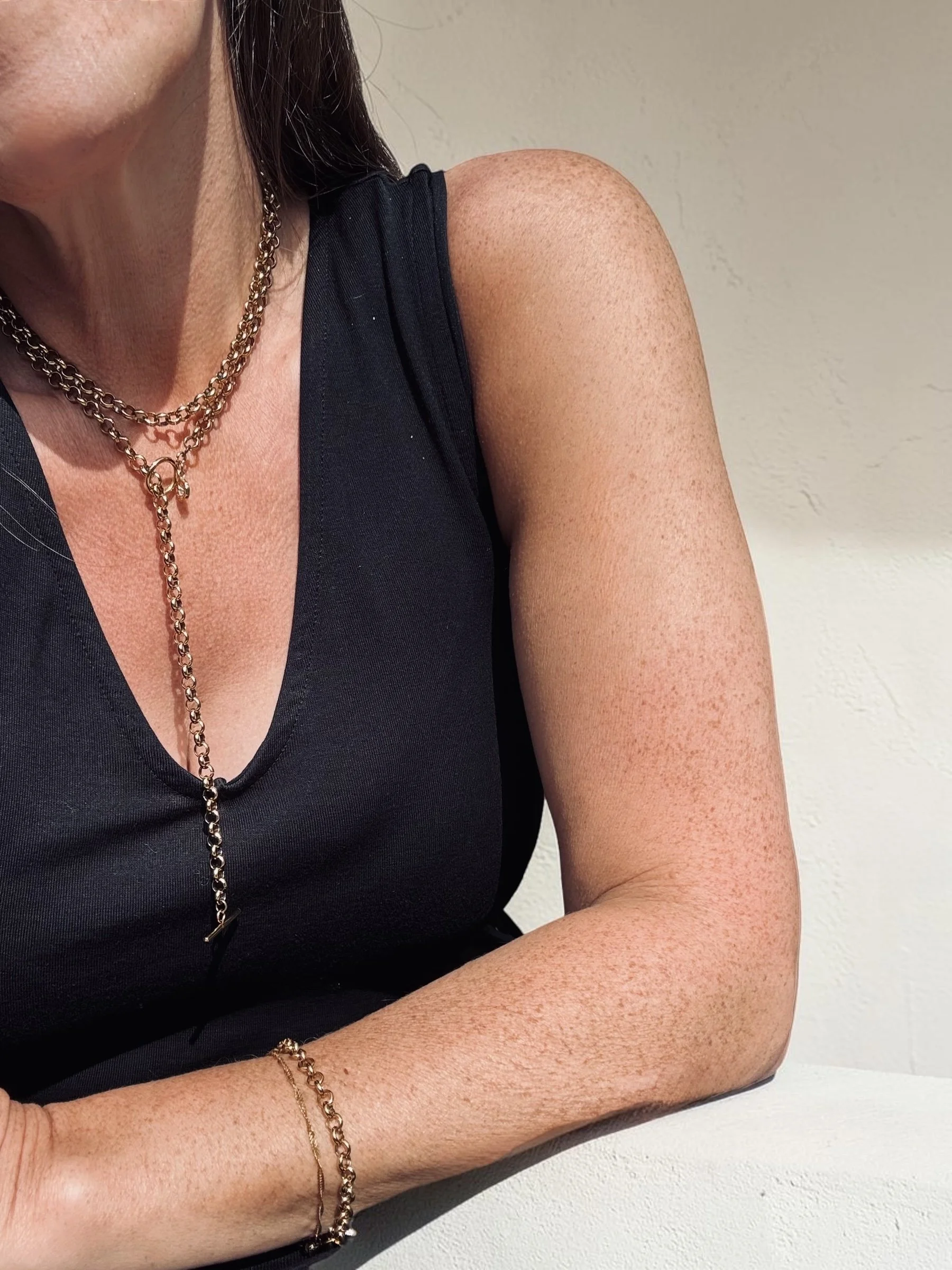 Gold wrap chain lariat necklace displayed on a white jewellery bust. Available from Chain Rule Jewellery.