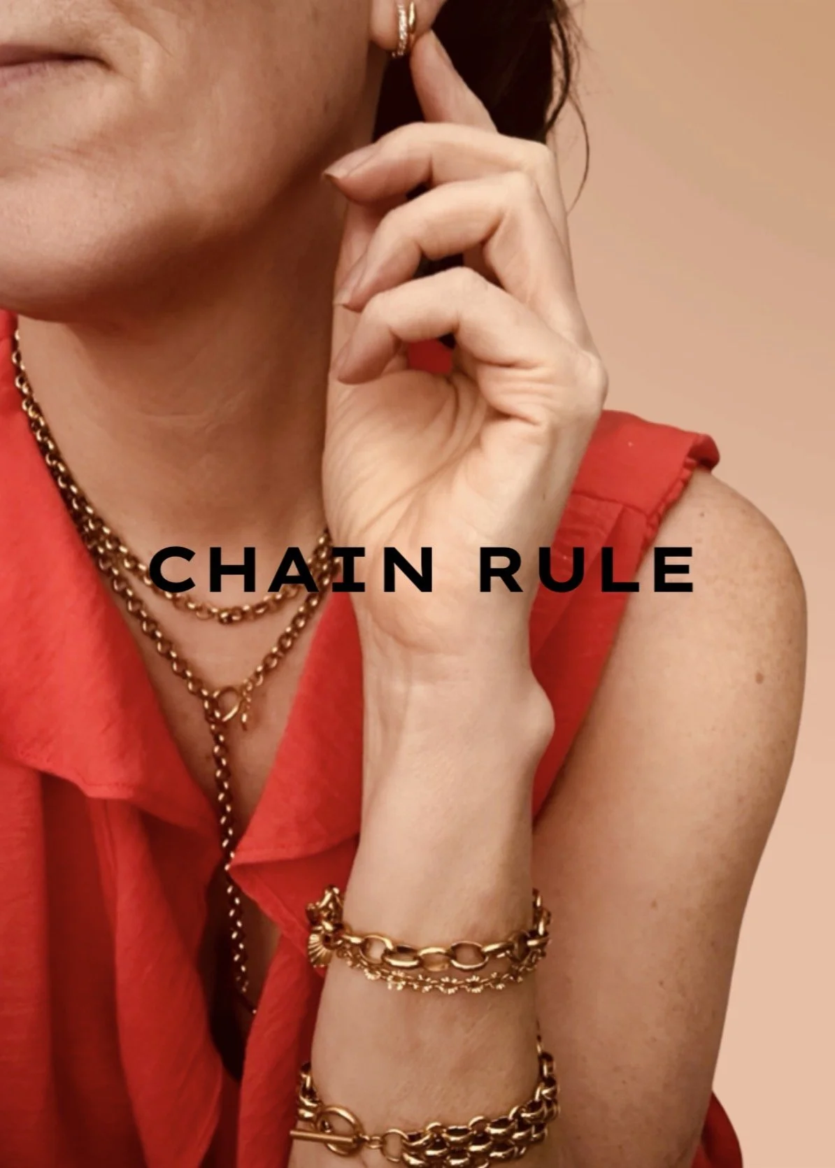 Close-up of a woman wearing gold jewelry, including layered necklaces and bracelets, in a red sleeveless top, with the words 'CHAIN RULE' overlaid.