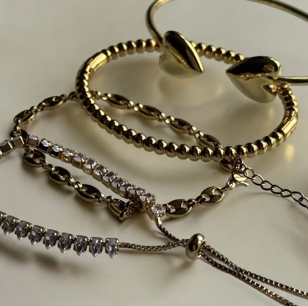 gold curb bracelet with small pink gemstone charm