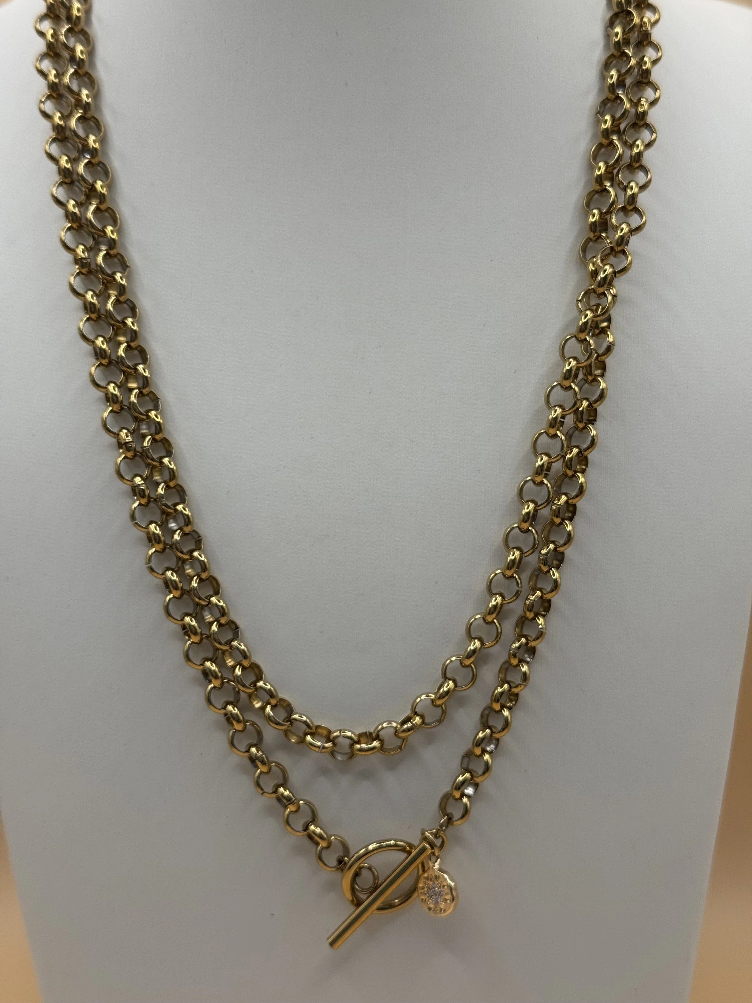 Chain Rule's Wrap lariat shown in a layered style with a toggle clasp and cubic zirconia charm.