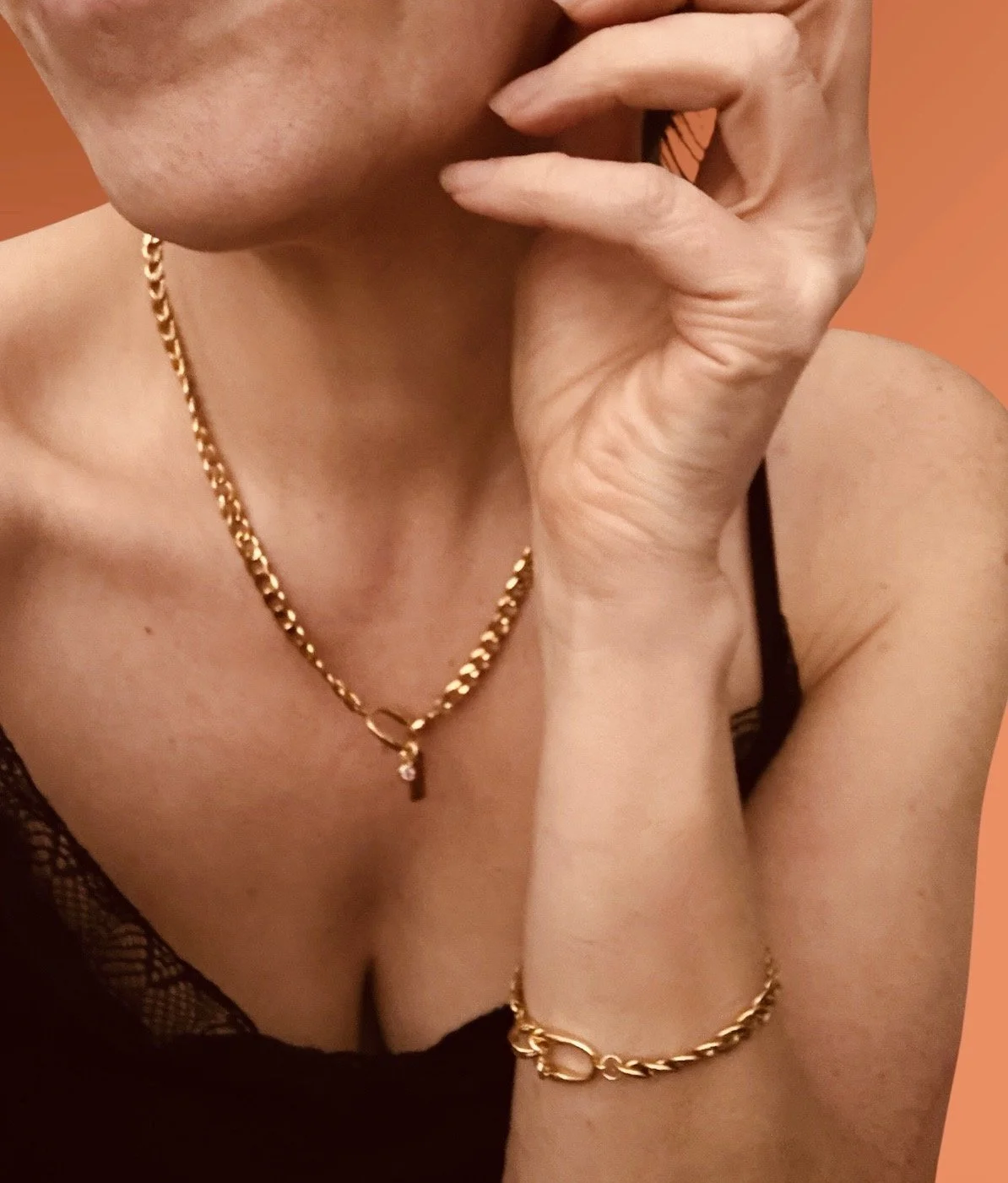 Gold curb chain necklace and bracelet set. Available at Chain Rule Jewellery. Necklace is displayed on a white bust and the bracelet on a cone. 