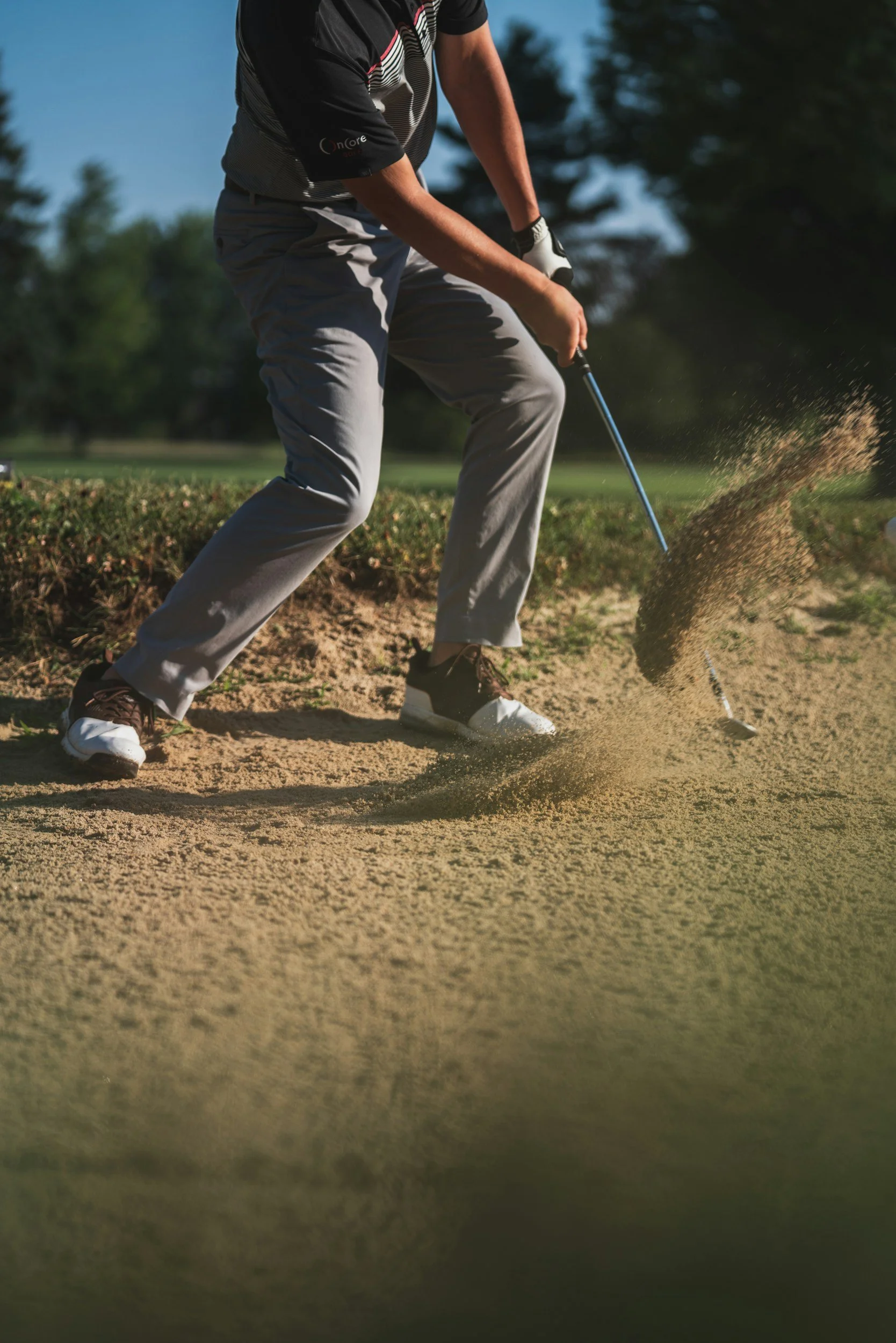 Man hitting a shot in sand trap