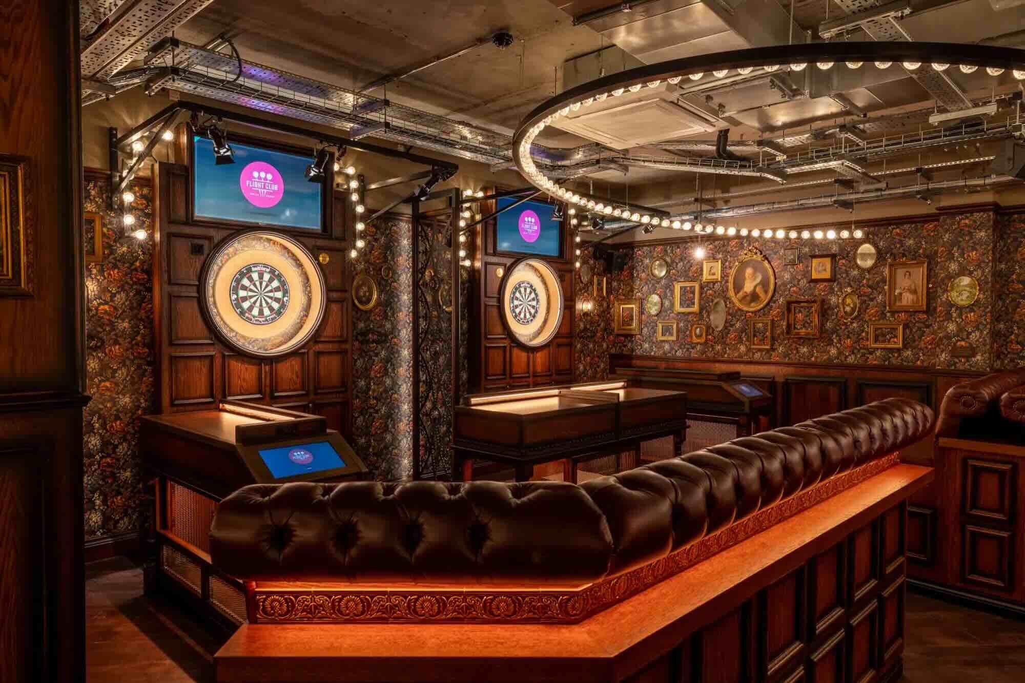 Darts lanes and bar seating in a competitive socialising environment, with warm lighting and vintage-inspired decor