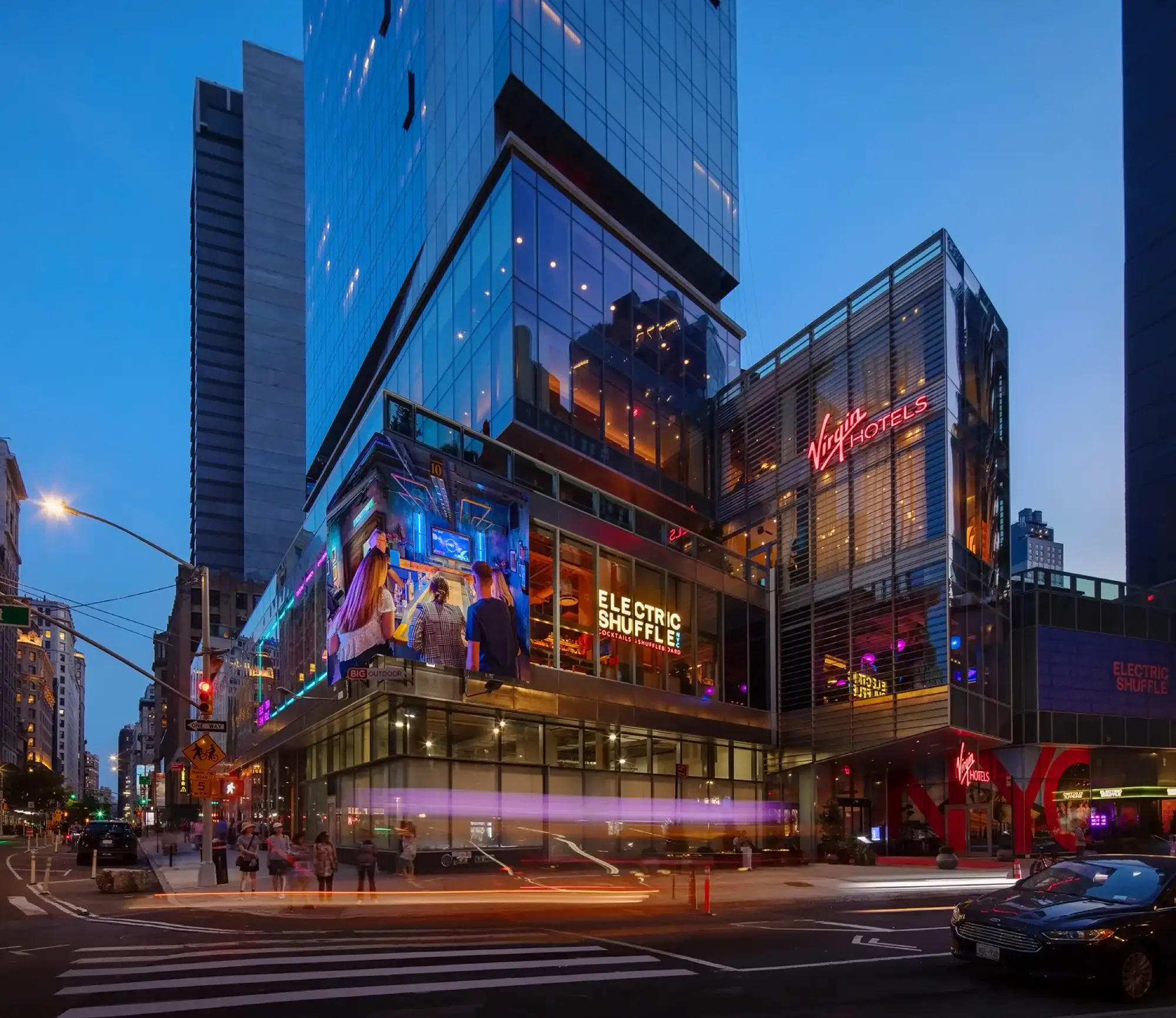 Electric Shuffle venue at Virgin Hotels New York, with illuminated signage and glass façade — interior design by Studio Hayes