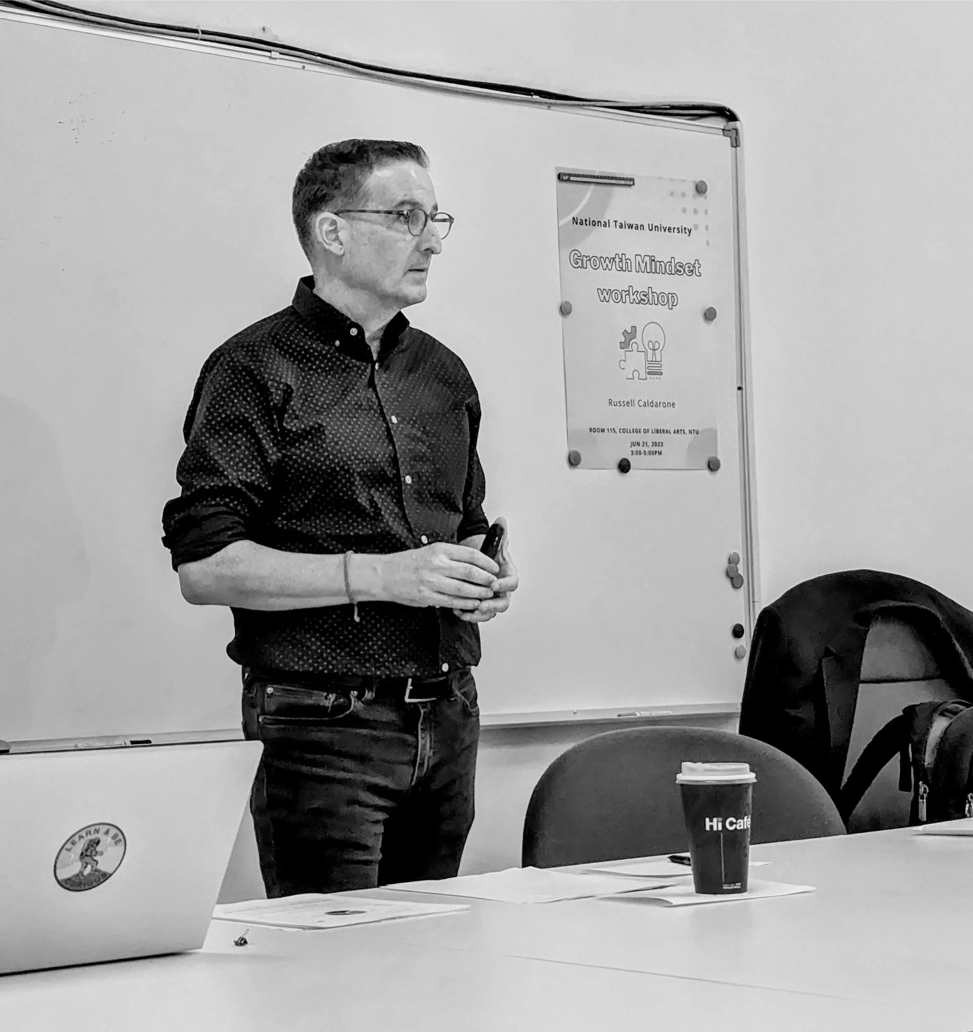 Russell Caldarone standing in front of a whiteboard during a workshop at National Taiwan University, with a sign on the wall that reads 'Growth Mindset Workshop' and displays the date June 21, 2023.