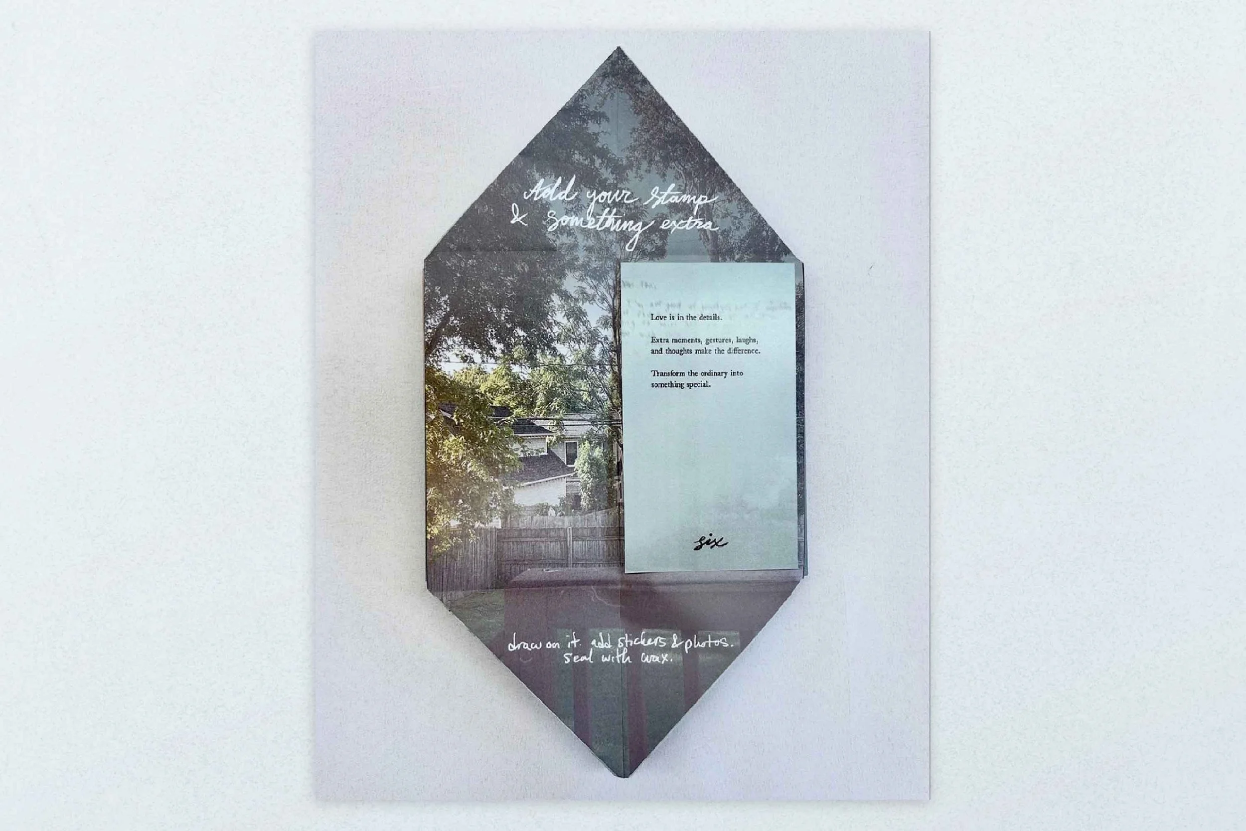 Decorative mirror with handwritten instructions for craft project on a white wall, featuring a background image of trees and a house.
