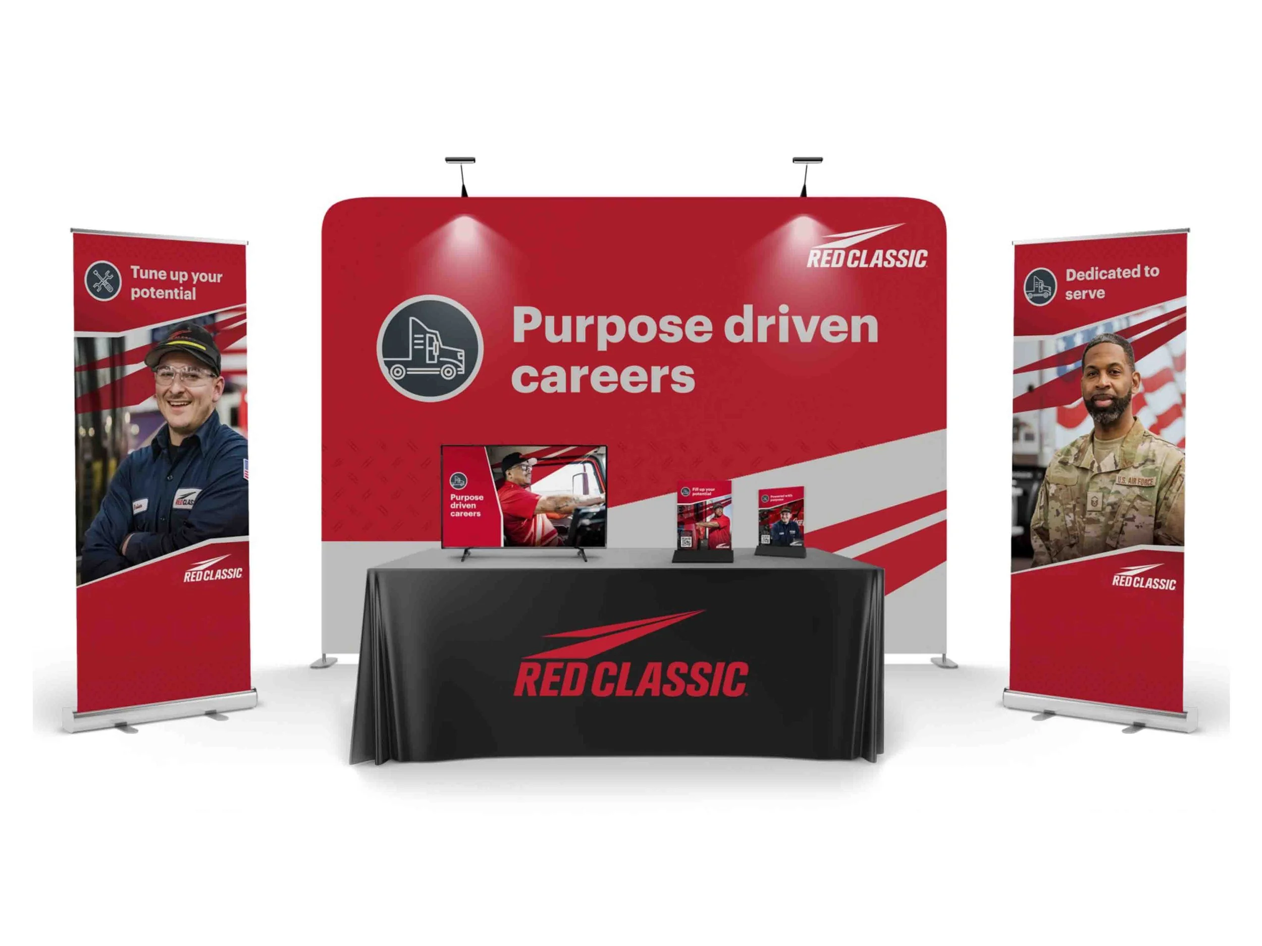 Trade show booth with Red Classic branding, featuring banners with truck drivers and the slogan 'Purpose driven careers,' a table with promotional materials, and a large red backdrop with the Red Classic logo and tagline.
