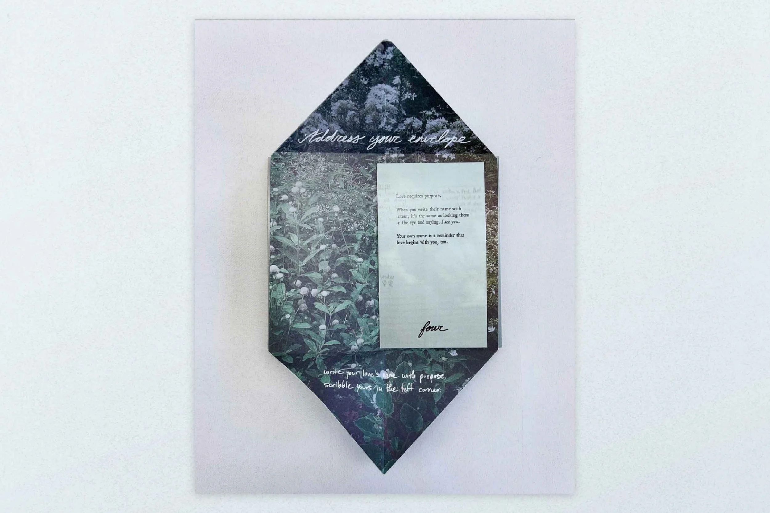 An envelope-shaped paper with a floral pattern, containing a sheet of paper with printed text and handwritten notes.