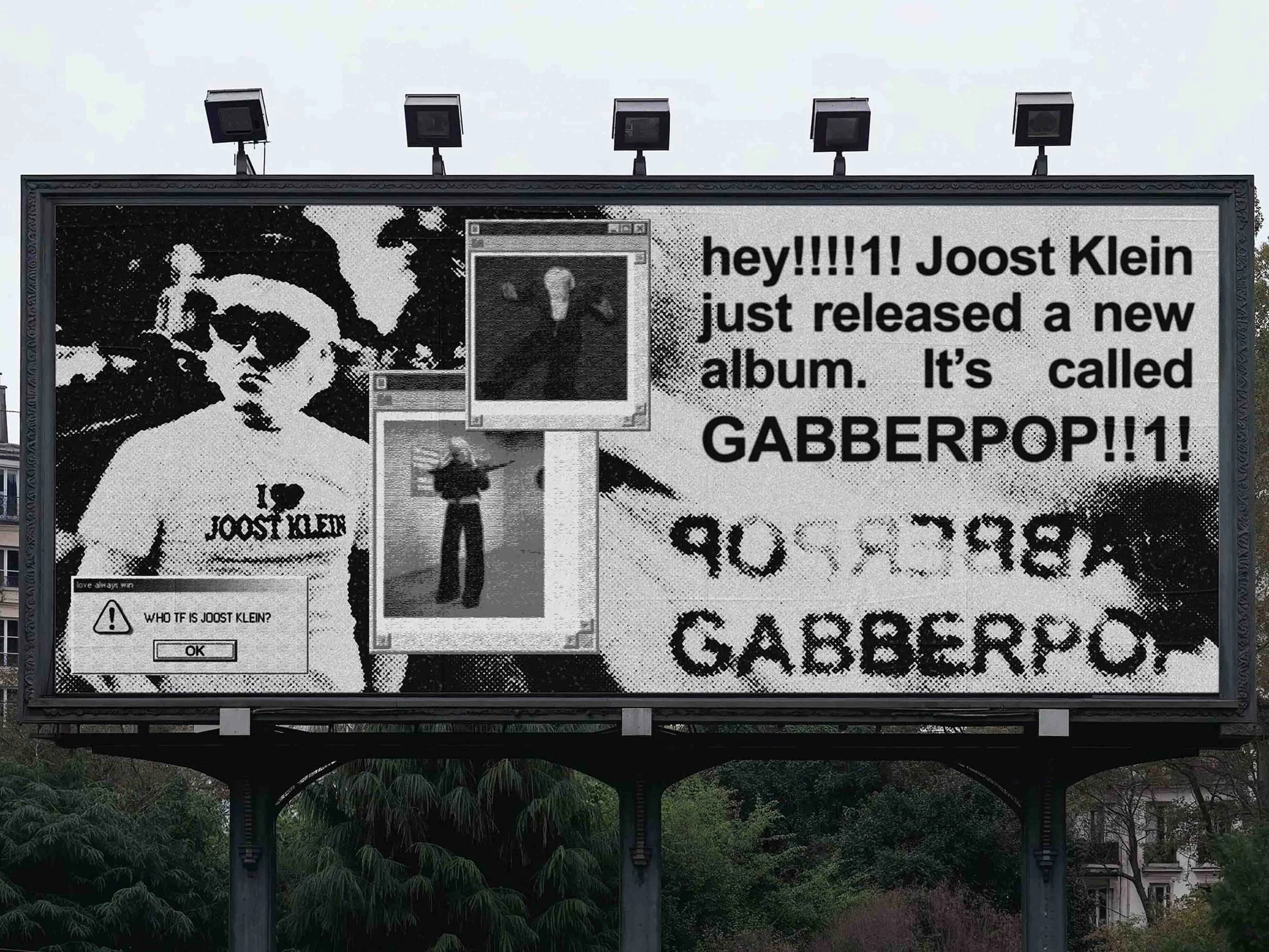 A large billboard with black-and-white graphics and text announcing Joost Klein's new album called GABBERPOP. The billboard features images of Joost Klein, digital windows, and a pop-up message asking "WHO TF IS JOOST KLEIN?"