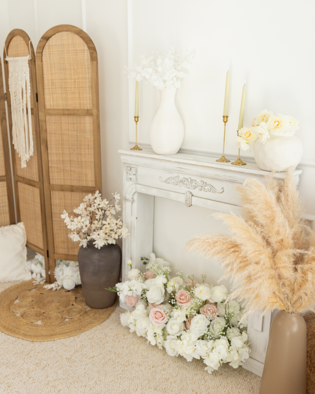 Décor intérieur avec vases de fleurs, bougies et un paravent en bois, ambiance élégante et neutre.