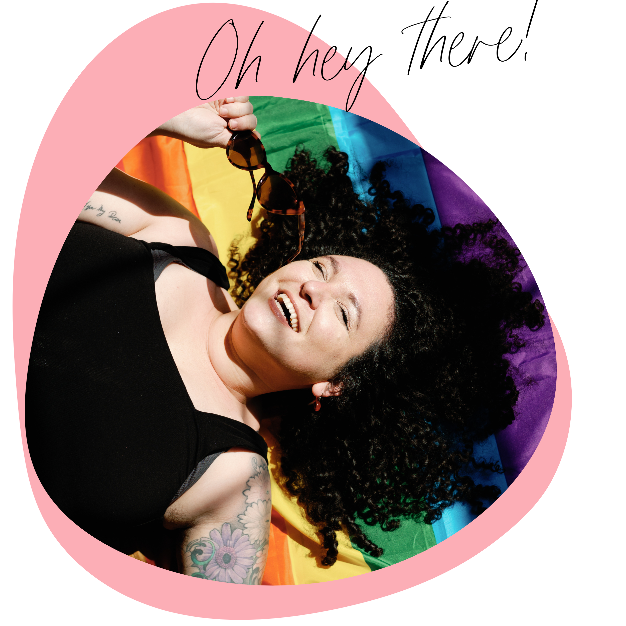 Woman with curly hair lying on rainbow-colored flag, smiling and holding sunglasses, with pink graphic overlay and handwritten text reading 'Oh hey'.