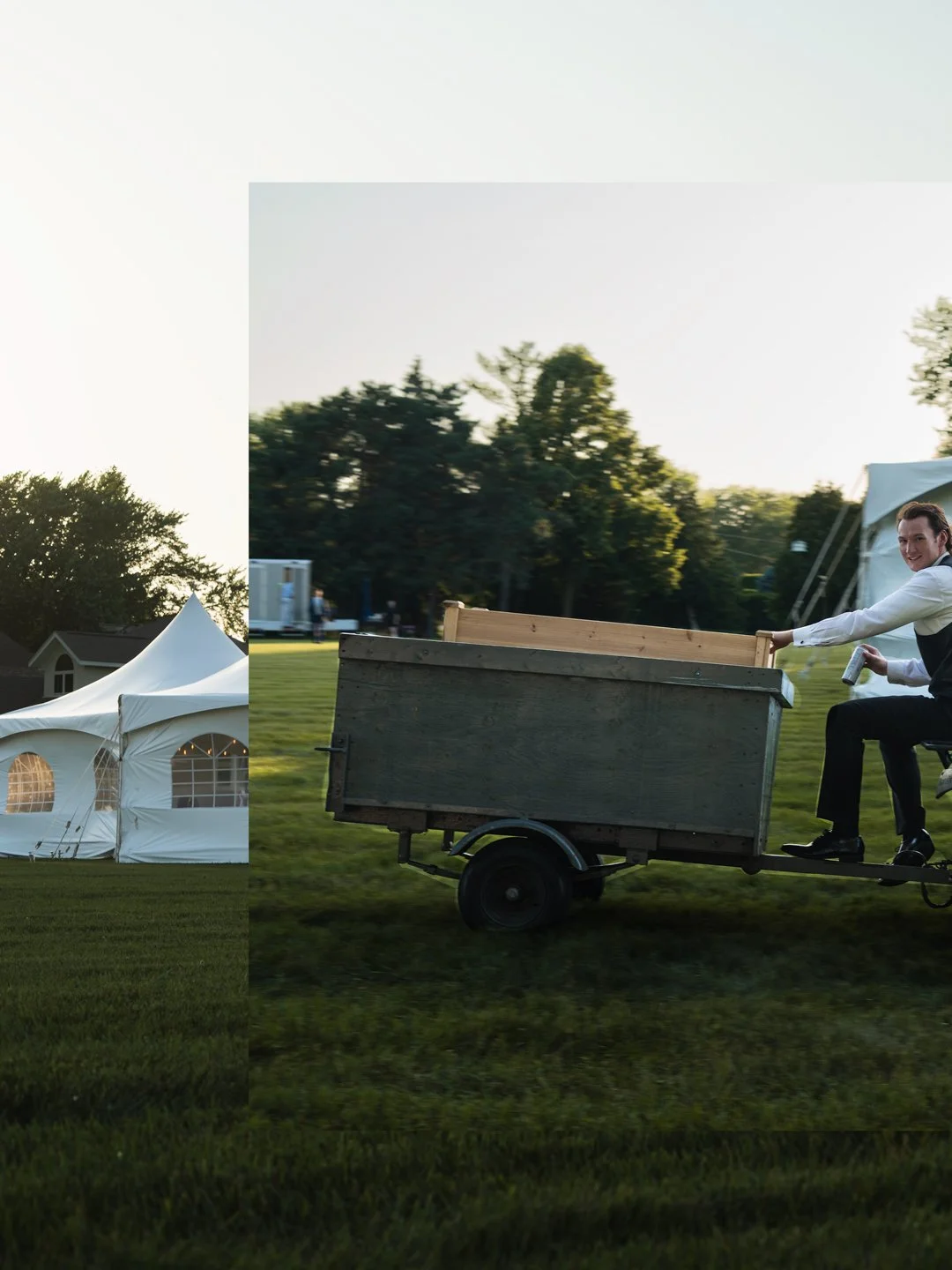 Man in formal attire riding a small motorized cart with a wooden railing on a grassy field during daylight, with tents and trees in the background.