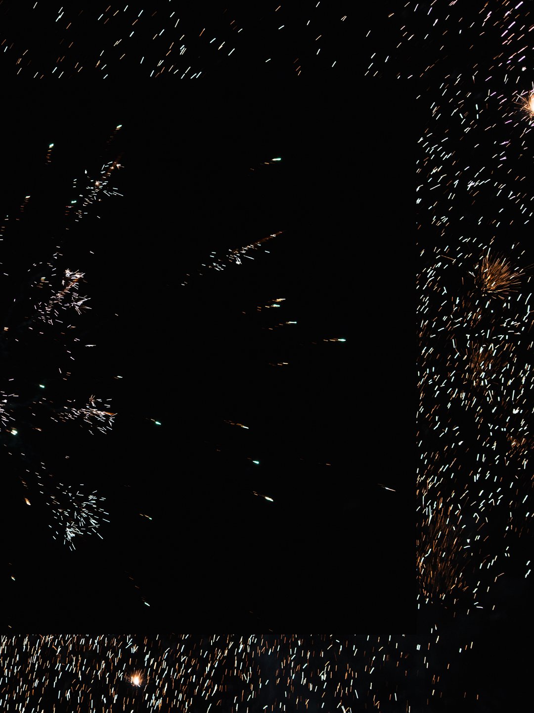 Fireworks display in the night sky with colorful exploding sparks.