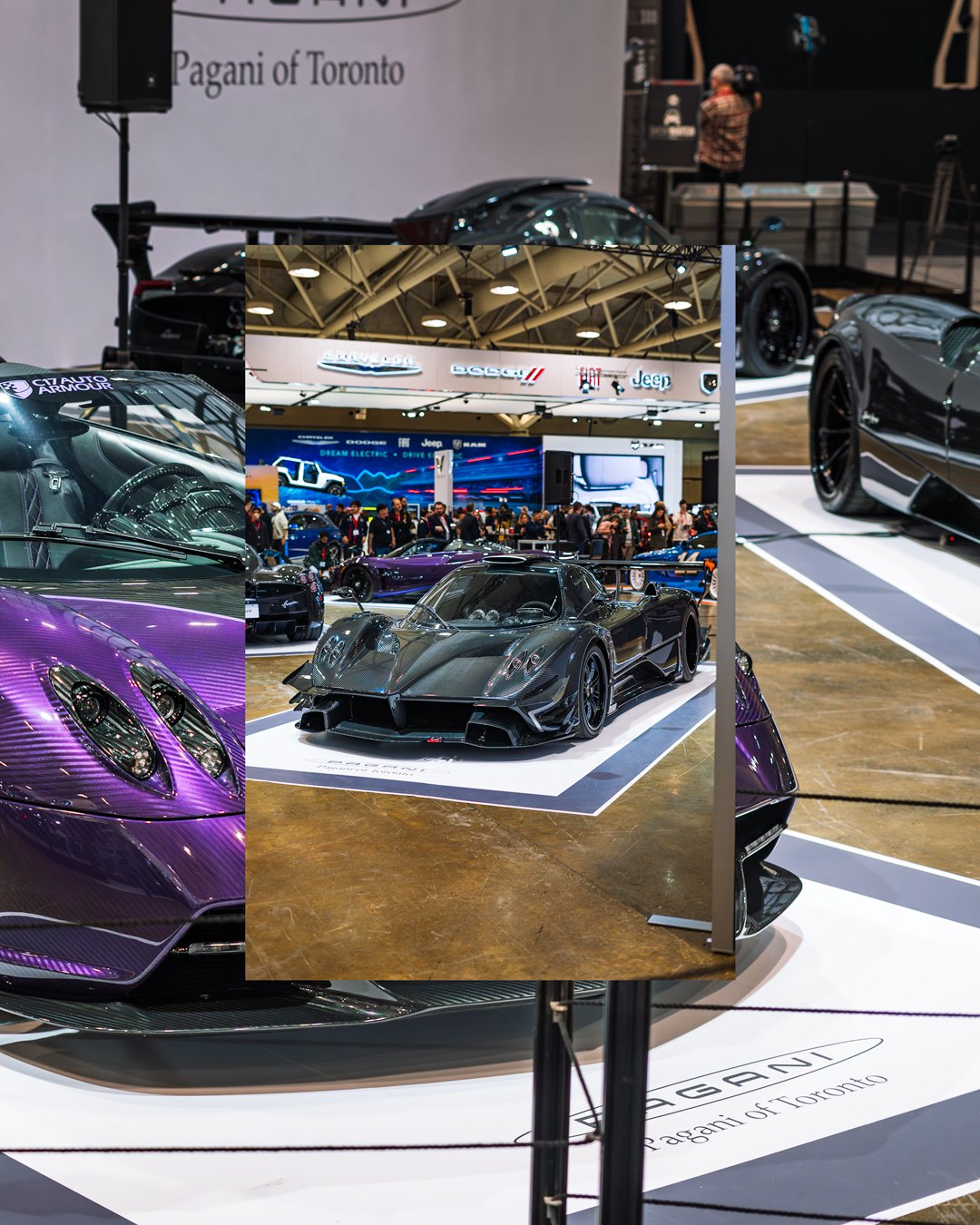 A display of high-performance sports cars at an auto show, with a focus on a sleek black race car reflected in a mirror, and various other cars visible around the exhibition space.