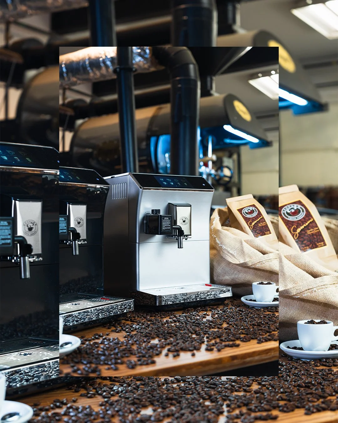 Two stainless steel coffee brewing machines on a wooden counter surrounded by scattered coffee beans, with coffee bags and cups of brewed coffee nearby.