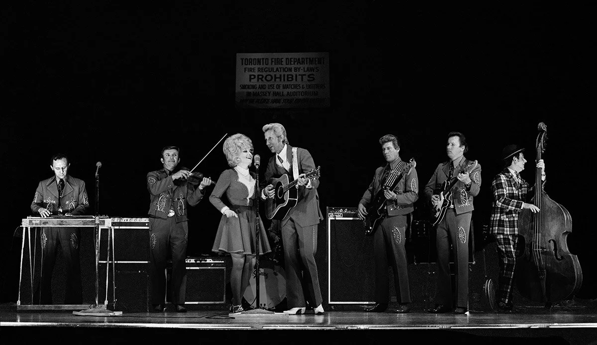 Hand-signed and numbered by John Rowlands, this museum-grade archival print captures Dolly Parton and Porter Wagoner at Massey Hall in 1972. Professionally scanned from the private archive and printed on heavyweight, acid-free fine art paper, documen