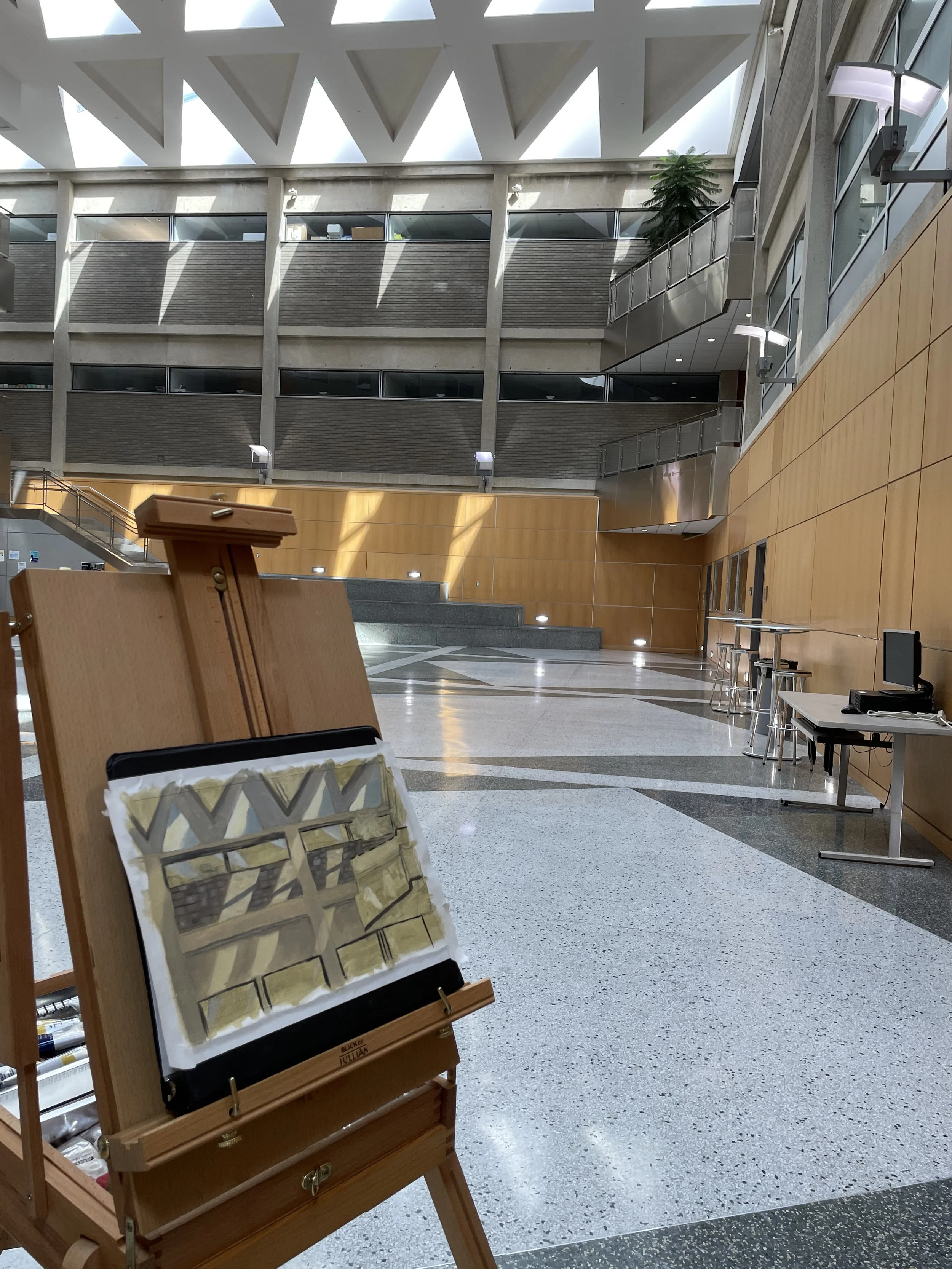 Easel holding a finished painting of the interior of a science building.