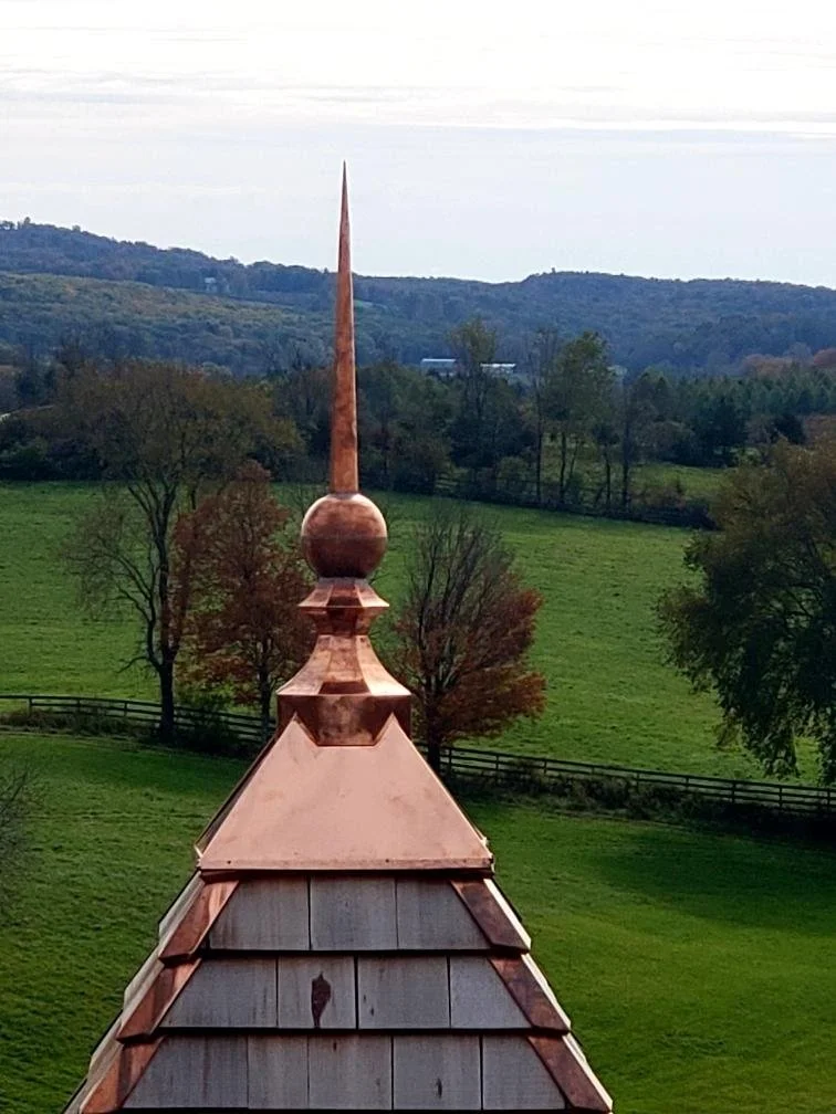 Copper rooftop spire with a pointed finial on a building by Custom Copper Co. in Newport, Rhode Island.