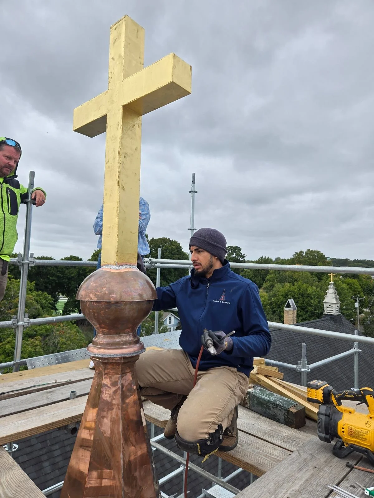 Gold leaf covered cross finial on a church by Custom Copper Co. in Newport, Rhode Island.