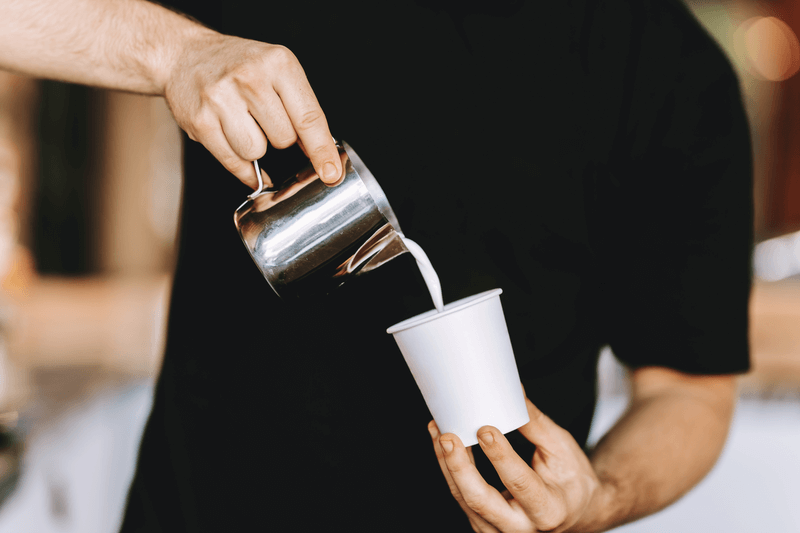 barista-carefully-pours-the-milk-into-a-glass.png