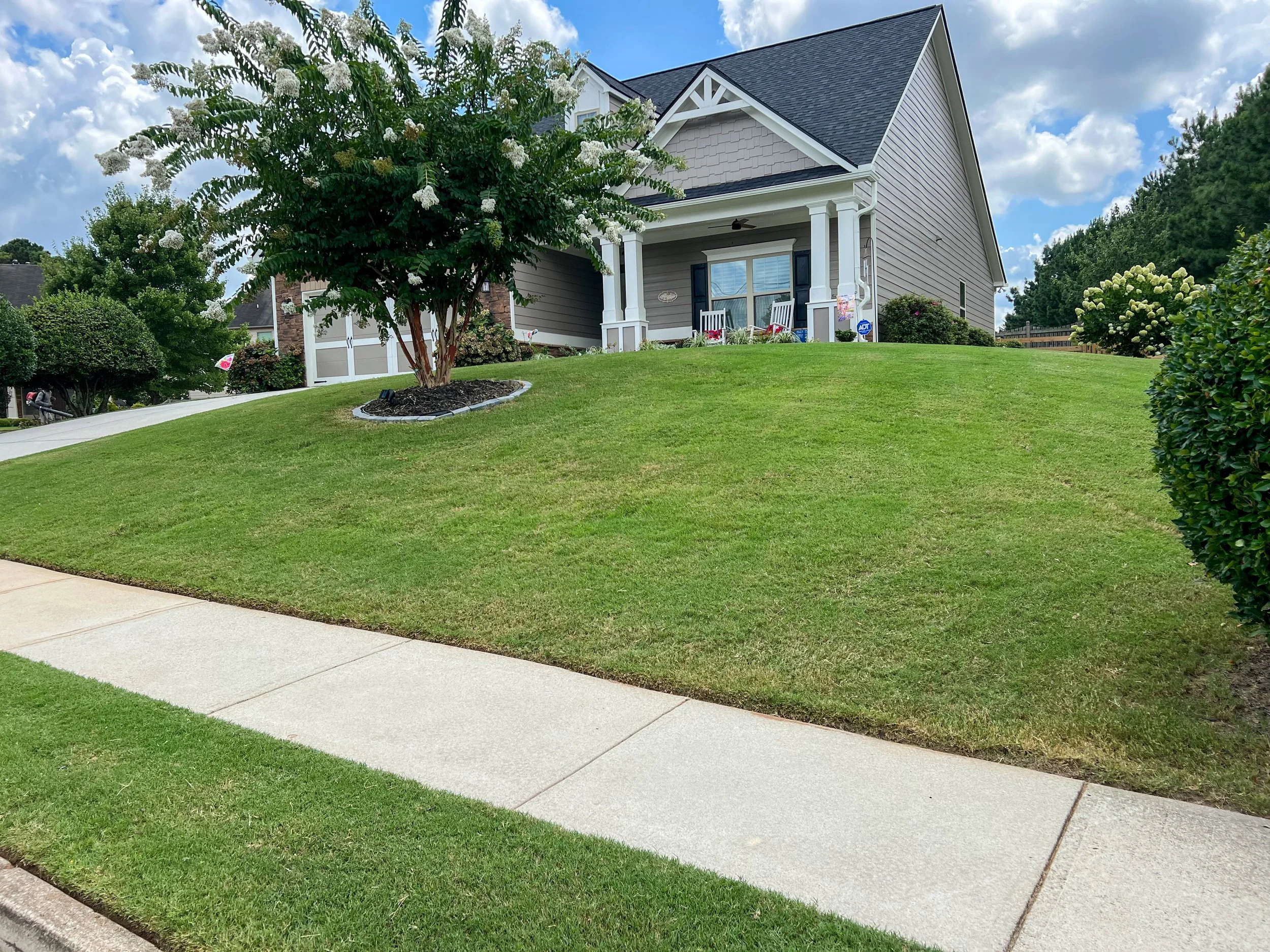 Routine lawn and landscape maintenance with shrub care at a residential property in the Seven Hills subdivision in Dallas, GA
