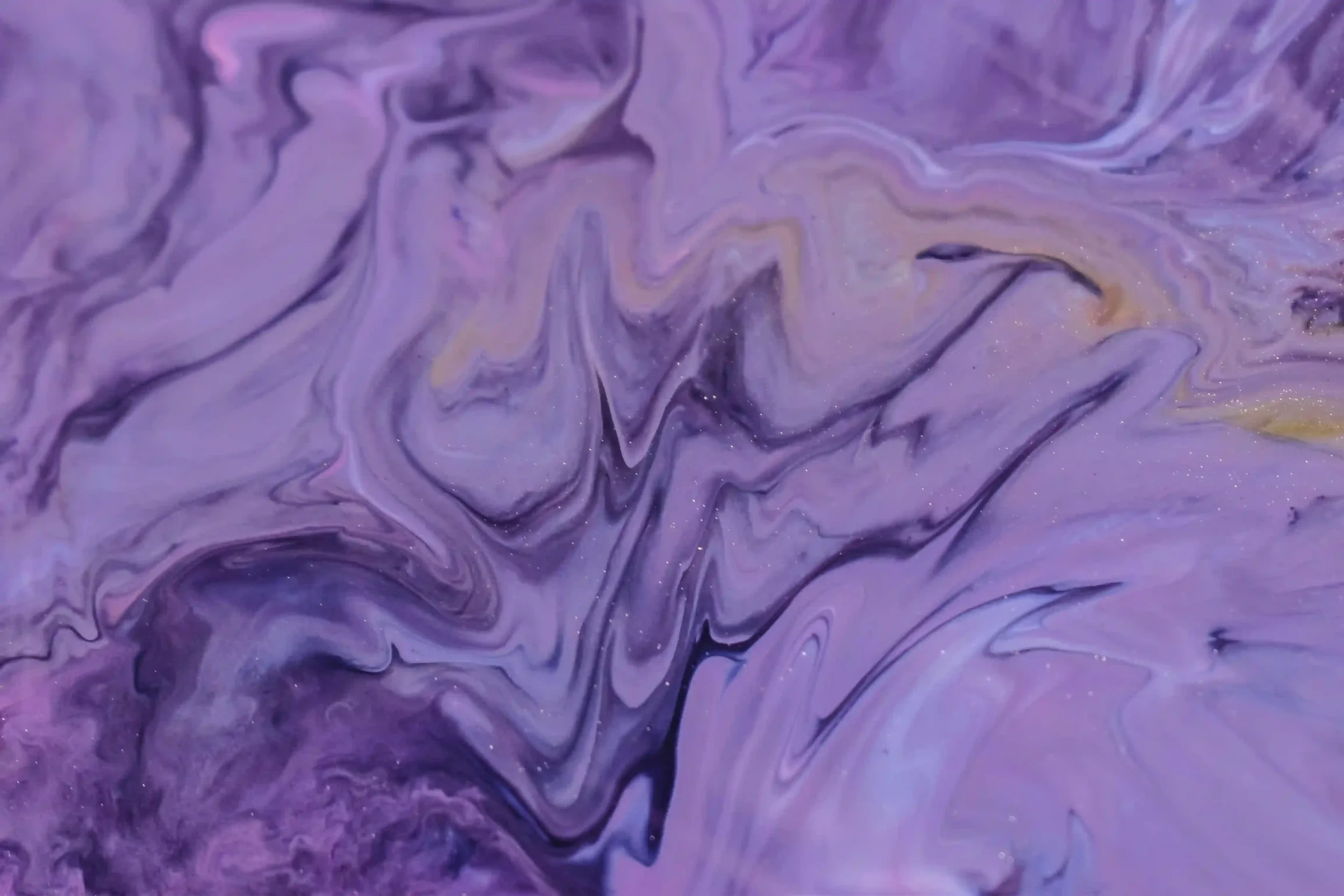 Marbled purple and yellow fluid swirling with shimmer and glitter accents.